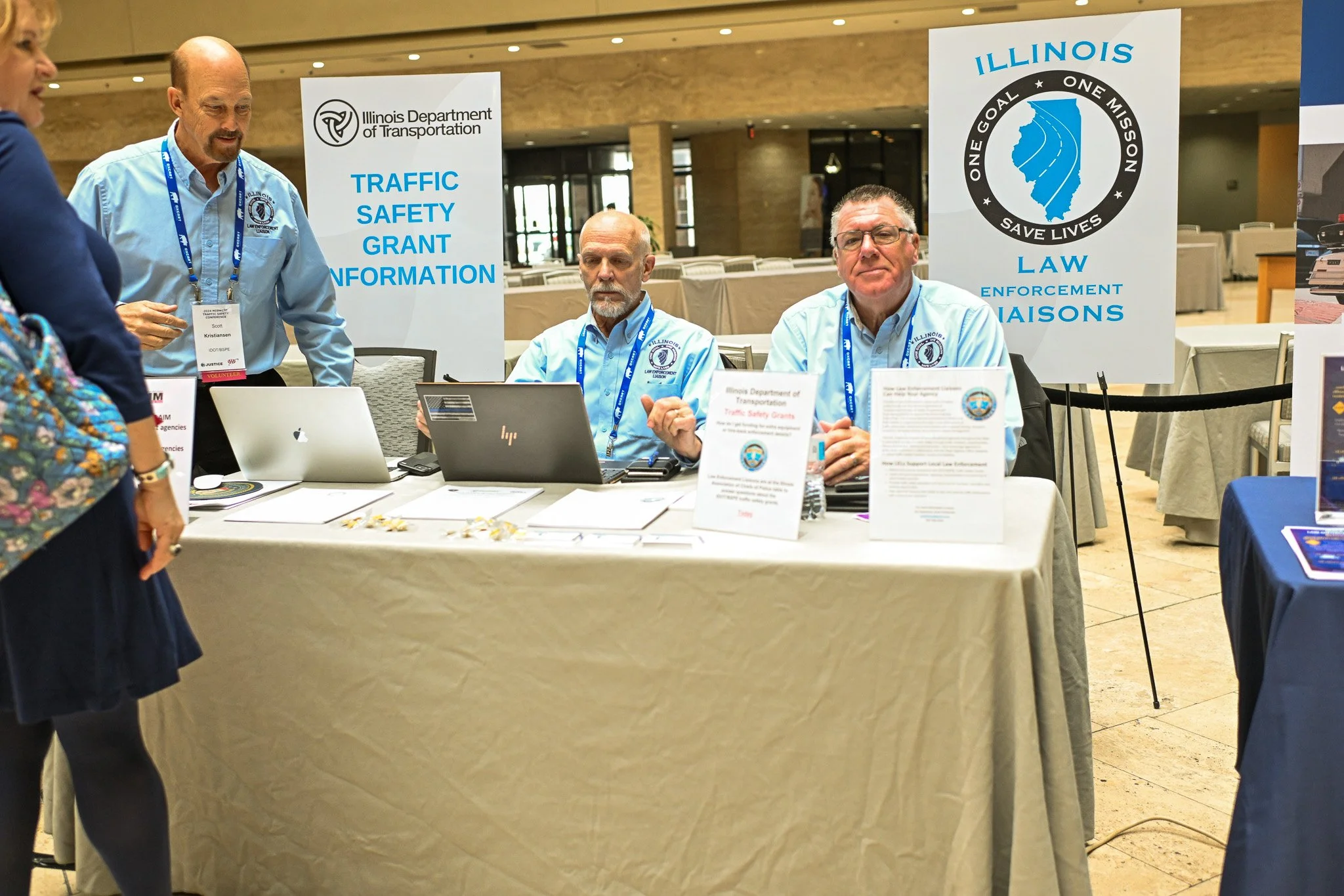 Illinois Department of Transportation officials at a booth providing traffic safety grant information during an event.
