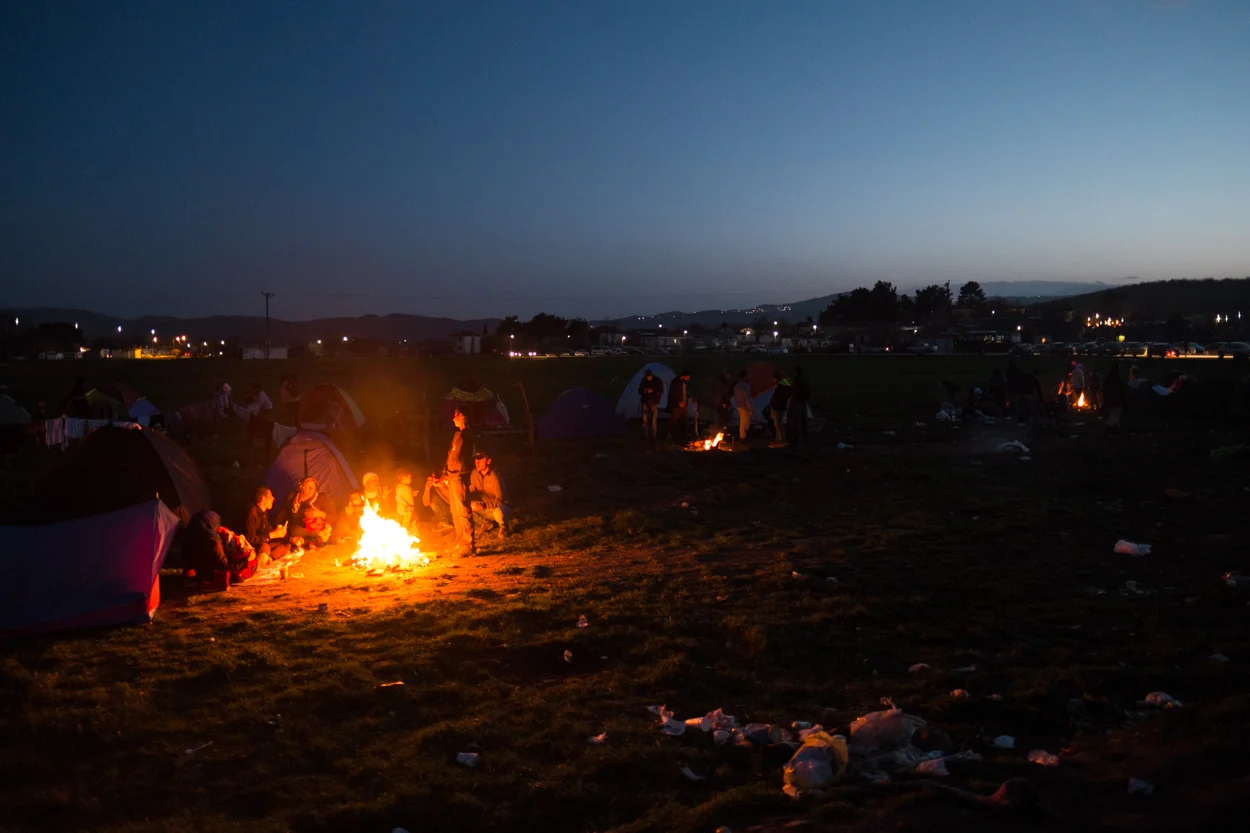 Idomeni, Greece – March 1, 2016 Refugees huddle around bonfires in a camp in Idomeni, Greece on the border with Macedonia (FYROM).