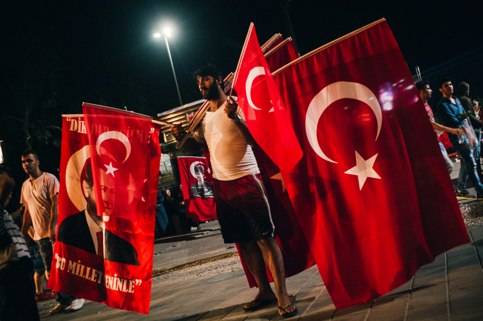 Aug. 6, 2016 - Istanbul, Turkey. A man sells Turkish flags, some emblazoned with the face of Turkish President Recep Tayyip Erdoğan, at a rally in Taksim Square. 