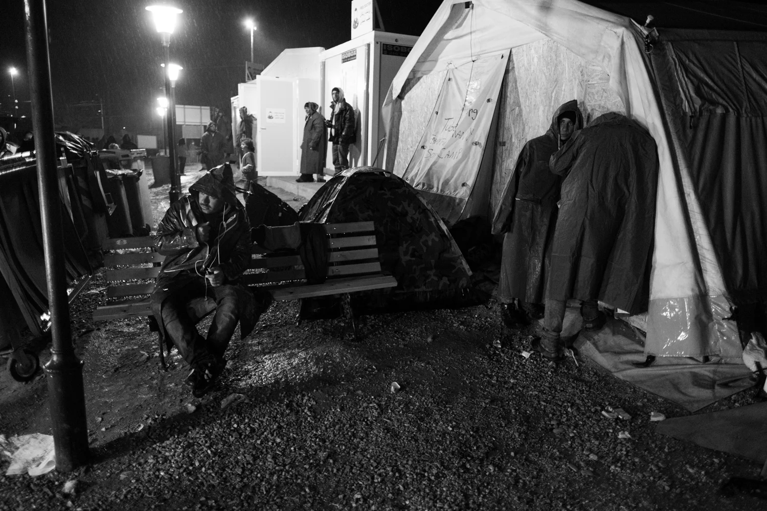 Refugees sit and stand in the rain. Idomeni Refugee Camp, Greece - March 3, 2016. Featured in 5 Journal .