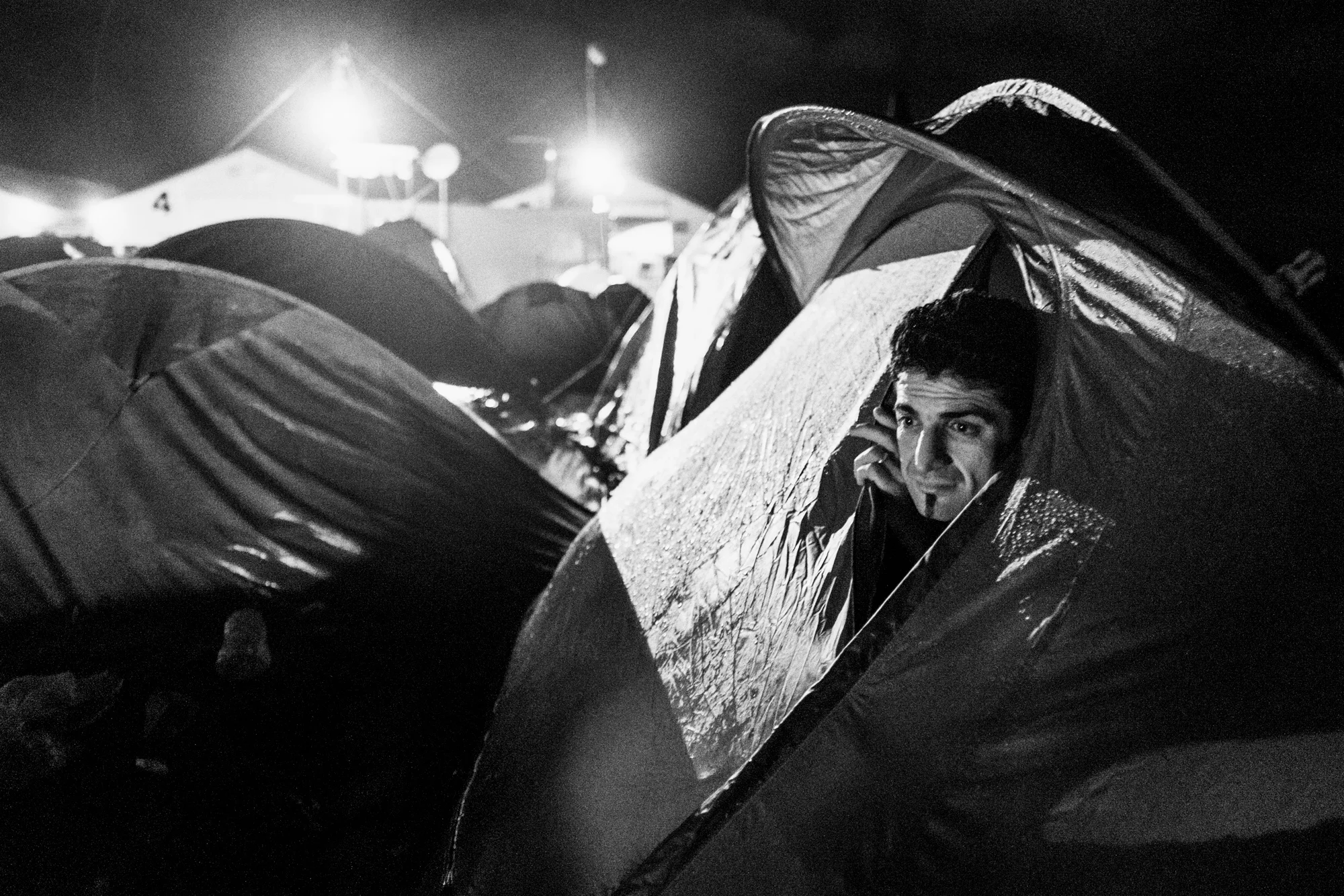 A man looks out from his tent. Idomeni Refugee Camp, Greece - March 3, 2016. At its height, the refugee camp in Idomeni held nearly 15,000 before it was cleared out in late May 2016. Idomeni became a flashpoint in the refugee crisis when Macedonia (FYROM) closed its borders on March 9, 2016. Featured in 5 Journal .