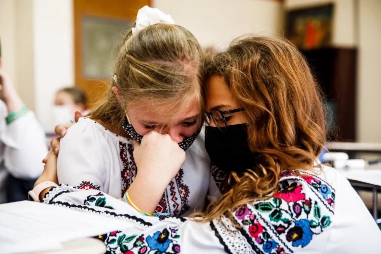 Anastasia Korolyk, right, hugs her friend and classmate Yulia Holiyat, who started crying after she talked about the war in Ukraine, at the Self-Reliance Saturday School of Ukrainian Studies in Saturday, Feb. 26, 2022, in New York. Julius Constantin