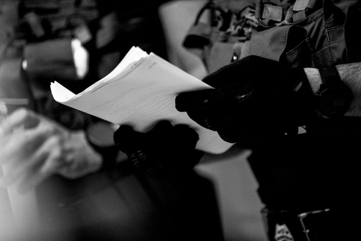  9:51AM: A federal agent looks through files containing information about migrants slated for detention at the Jacob K Javits Federal Building in New York on 16 July 2025.  Julius Constantine Motal/ The Guardian  
