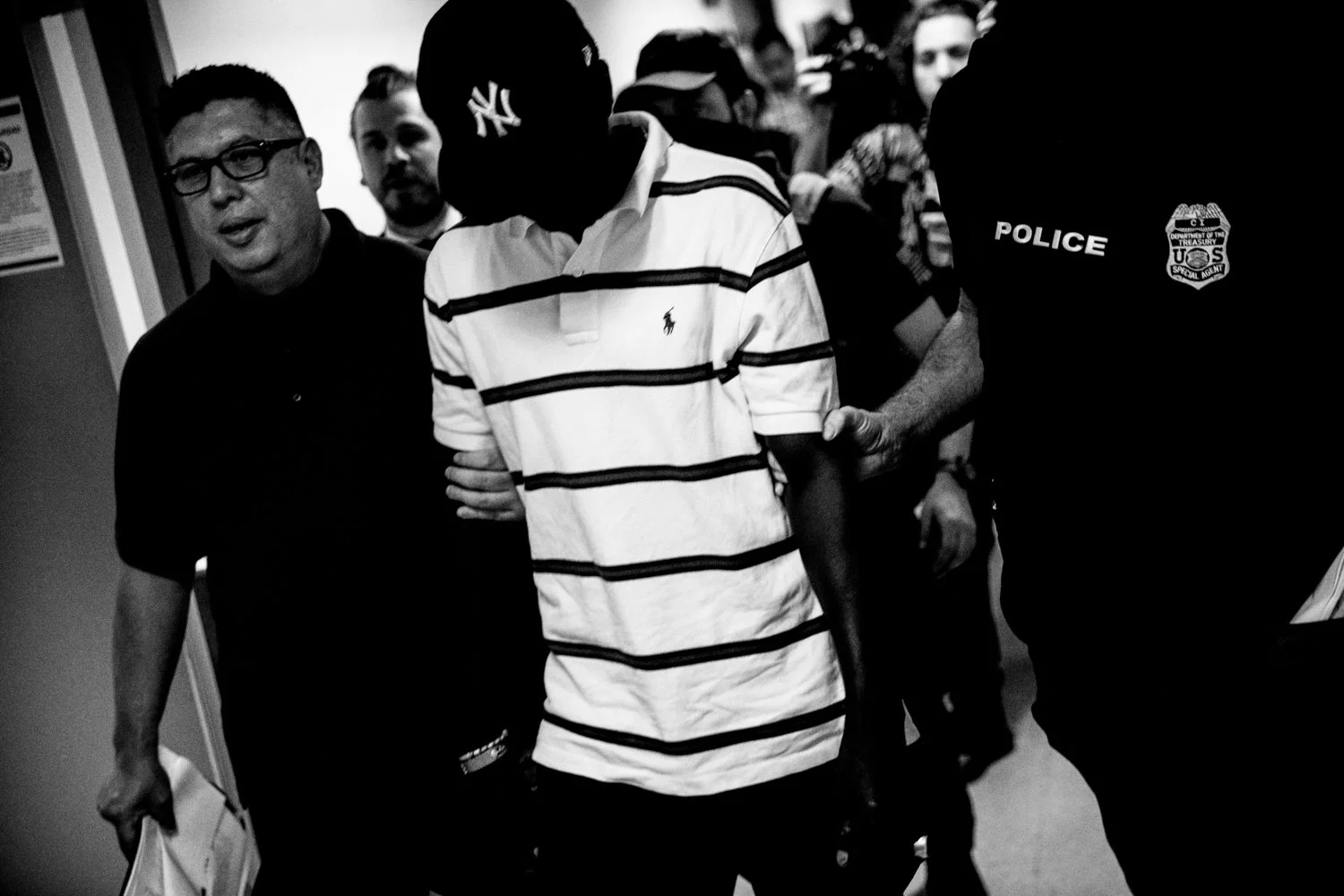  10:30 AM: Federal agents escort a detained man to a stairwell in the Jacob K Javits Federal Building in New York on 16 July 2025.  Julius Constantine Motal/ The Guardian  