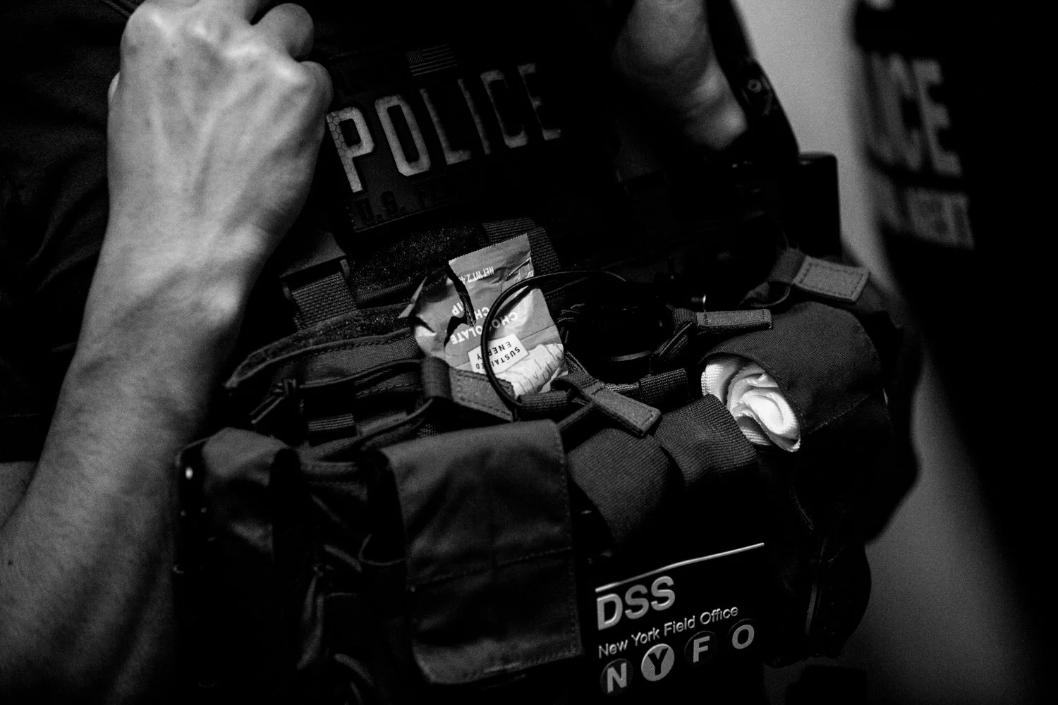  12:58 PM: A half-eaten Clif bar sticks out of a tactical carrier worn by a federal agent in the Jacob K Javits Federal Building in New York on 16 July 2025.  Julius Constantine Motal/ The Guardian  