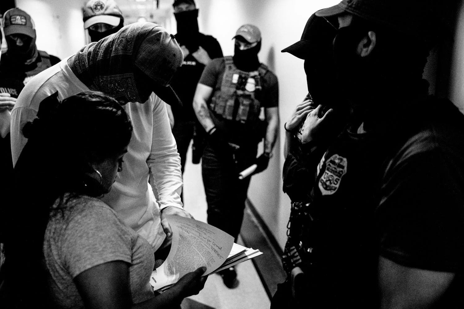  1:51 PM: A federal agent checks a woman's documents and allows her to leave following her immigration hearing in the Jacob K Javits Federal Building in New York on 16 July 2025.  Julius Constantine Motal/ The Guardian  
