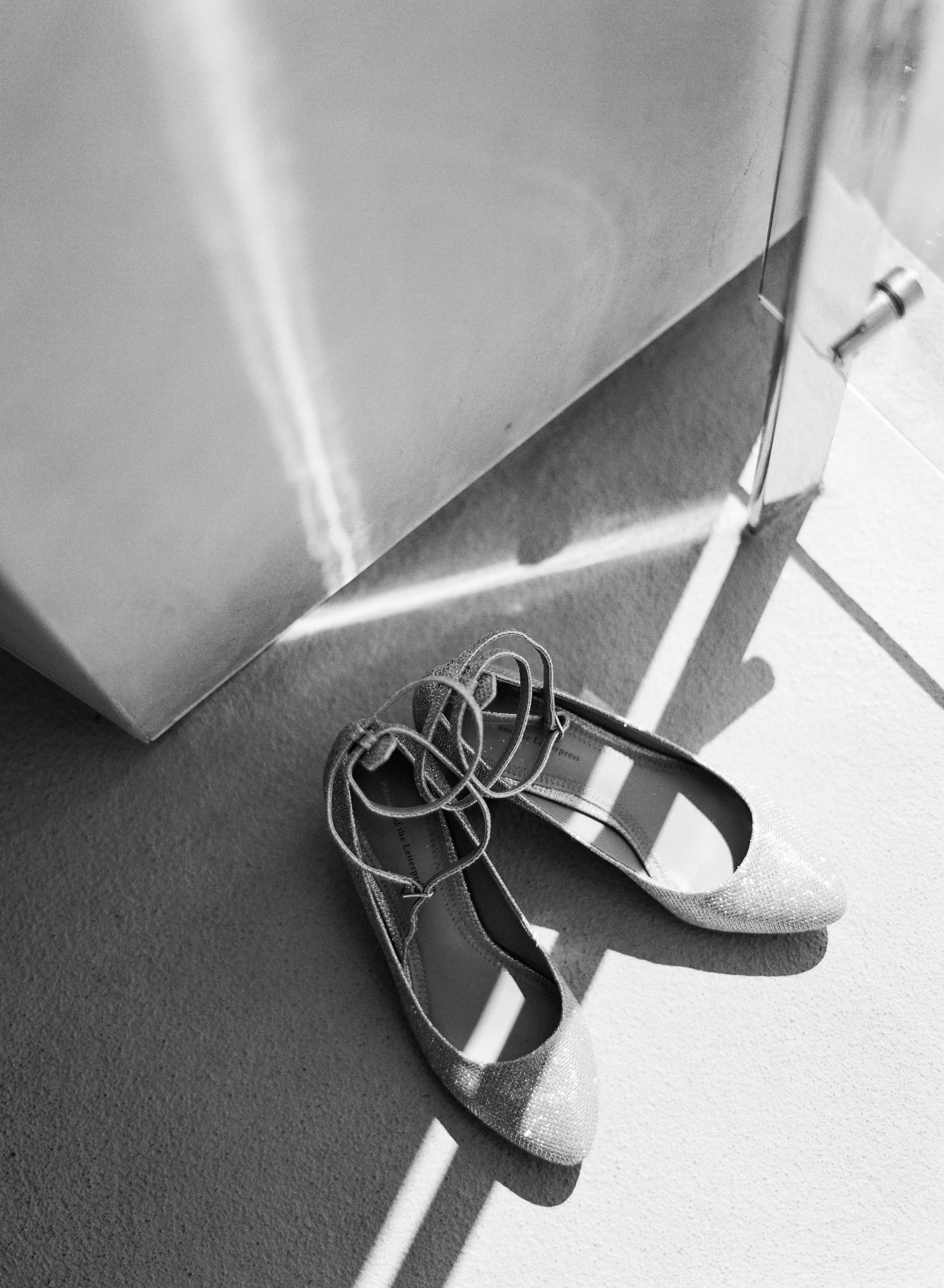 destination wedding photographer shoots orthodox jewish wedding and bride's wedding shoes in black and white film photography