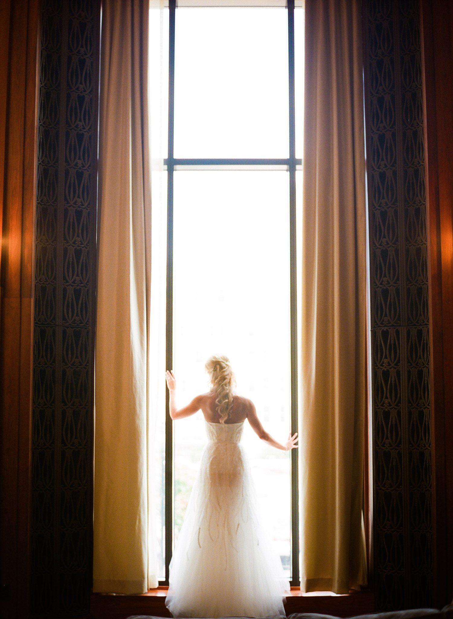 top destination wedding photographer Lexia Frank photographs the wedding of NFL football star Green Bay Packer Bryan Bulaga's wedding at the hilton in milwaukee as the bride stands in the doorway