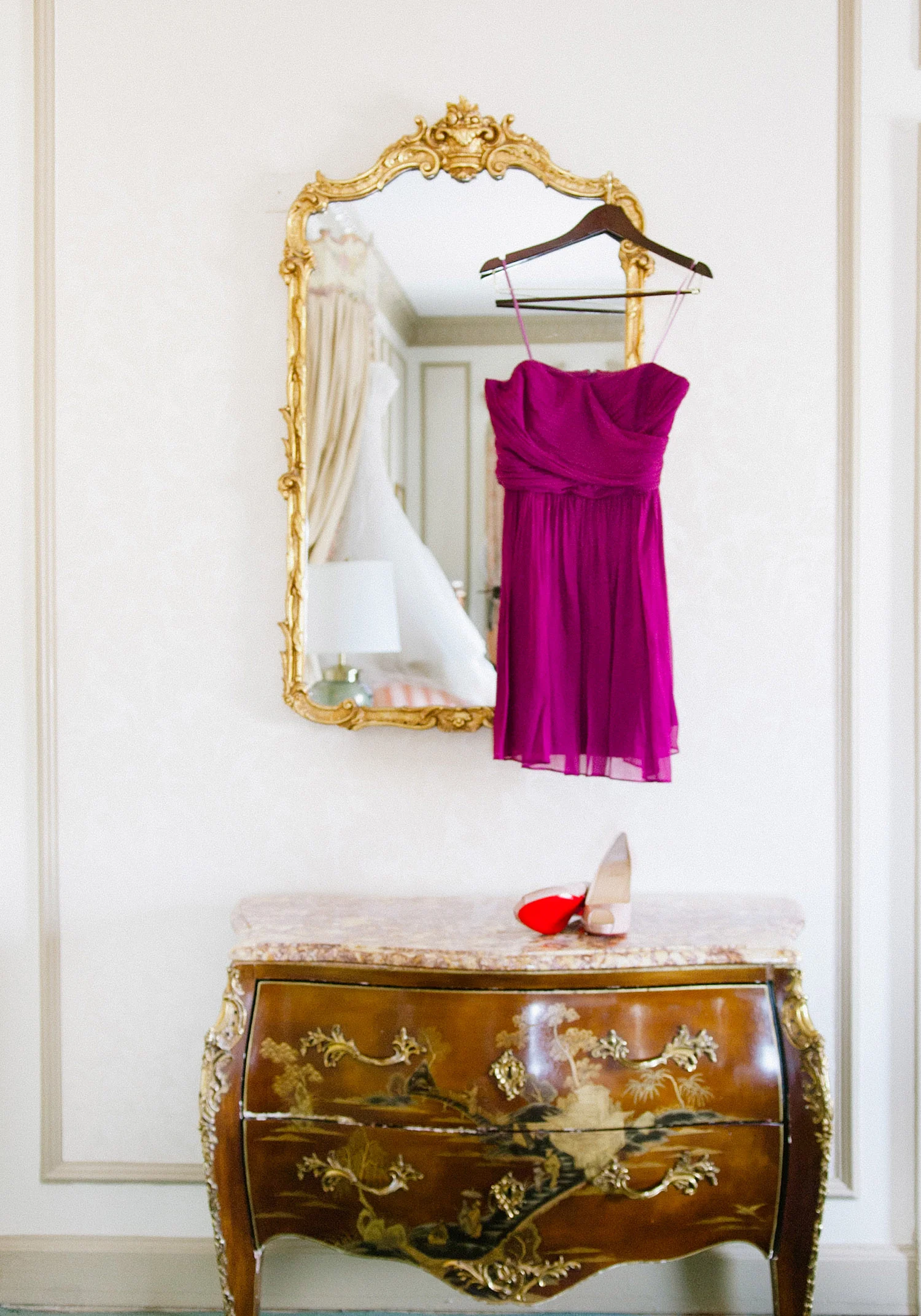 destination wedding photographer photographs pro football star Green Bay Packer Bryan Bulaga's wedding wedding at the hilton in milwaukee. purple bridesmaid dress with Christian Louboutin shoes sit on the dresser with the wedding dress in the mirror of the hilton downtown milwaukee