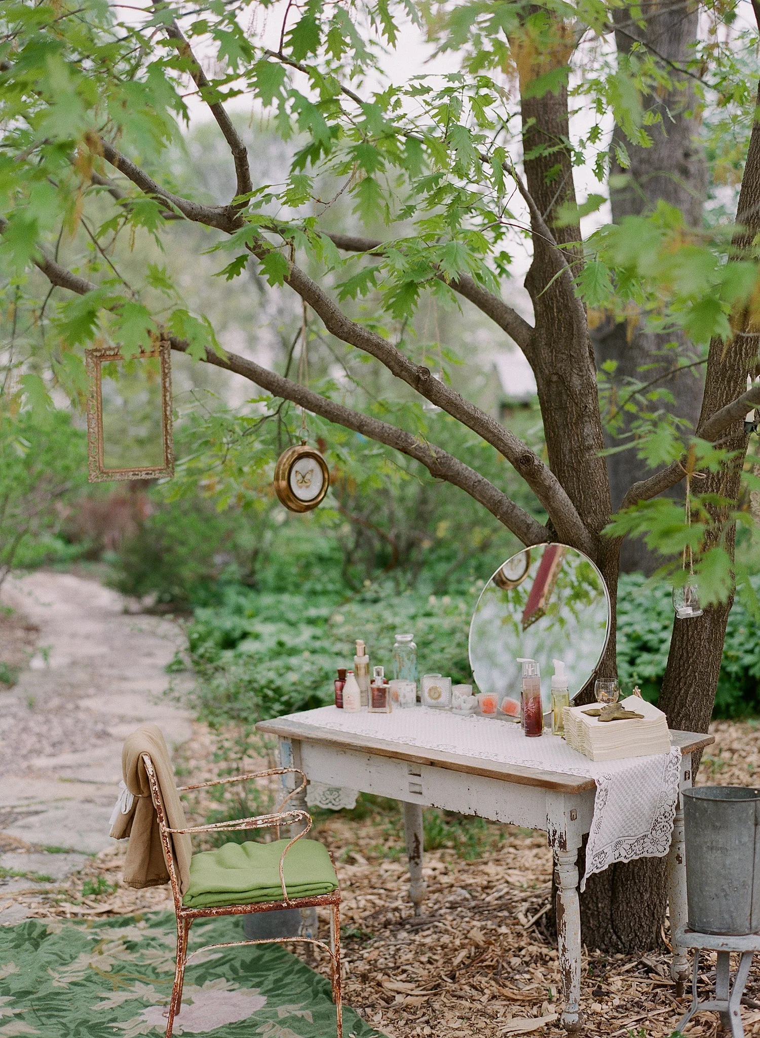 bride gets ready outside at a vintage table at the Northwind Perennial Gardens in Wisconsin while Destination Wedding Photographer Lexia Frank photographs in film 