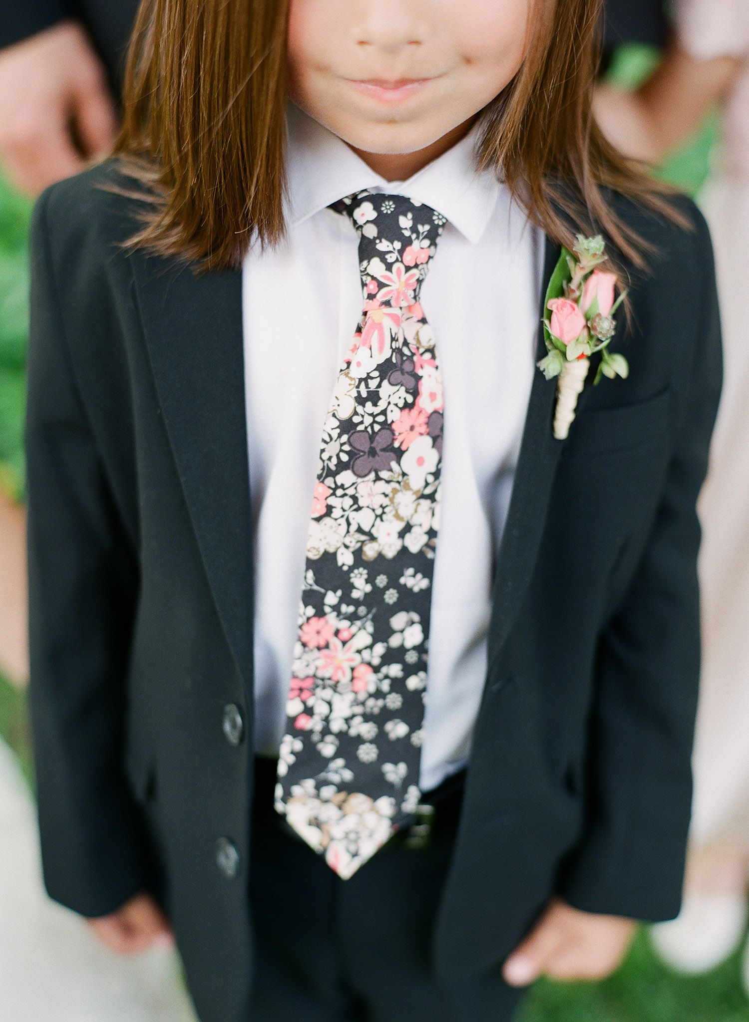 an adorable ringbearers outfit with a floral tie at this springtime wedding at Northwind Perennial Gardens -a beautiful wisconsin wedding venue - while Destination Wedding Photographer Lexia Frank photographs this wedding on film 