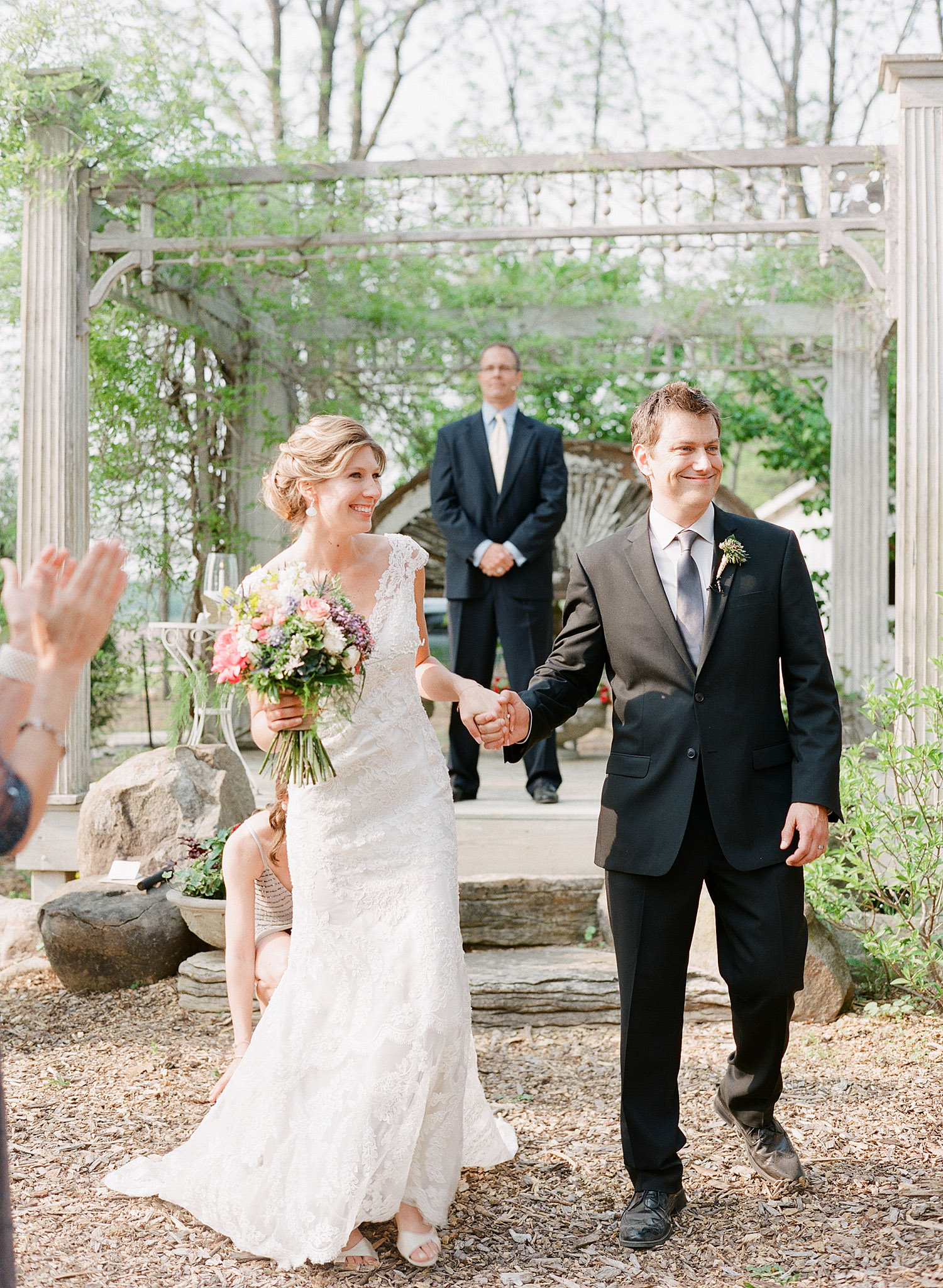 bride and groom walk down the aisle at this springtime wedding at Northwind Perennial Garden - a beautiful wisconsin wedding venue - while Destination wedding photographer Lexia Frank Photographs this wedding on film
