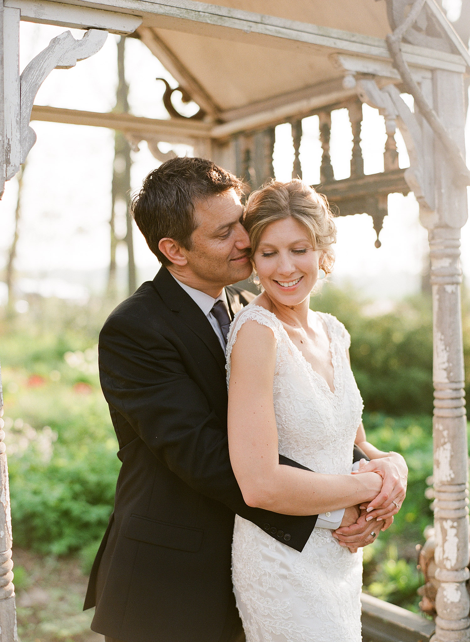 bride and groom kiss in the gazebo at this springtime wedding at Northwind Perennial gardens - a wisconsin wedding venue - as a film wedding photographer Lexia Frank photographs this destination wedding on film