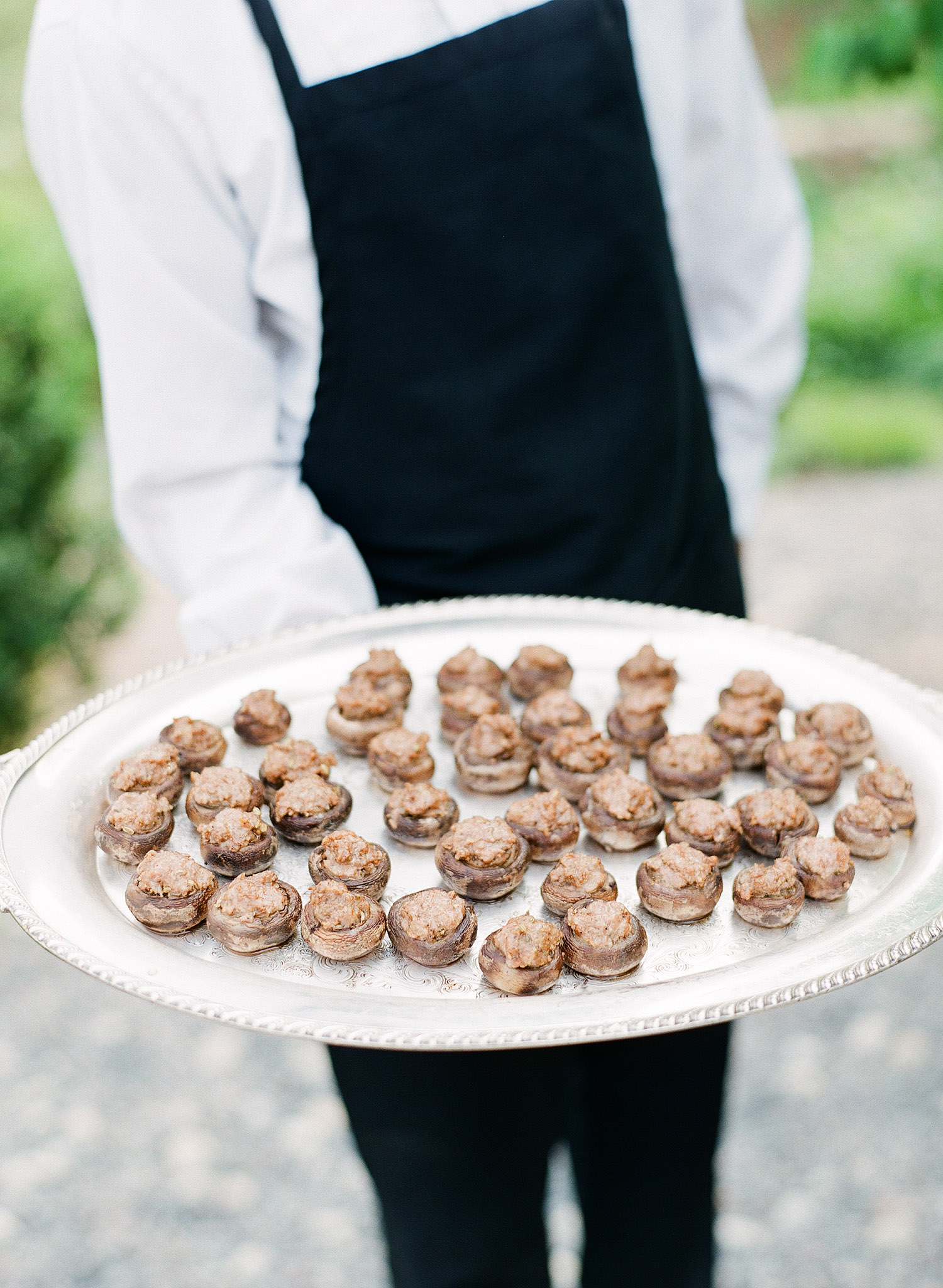 stuffed mushrooms are served on silver platters at this springtime wedding at Northwind Perennial gardens - a wisconsin wedding venue - as a film wedding photographer Lexia Frank photographs this destination wedding on film