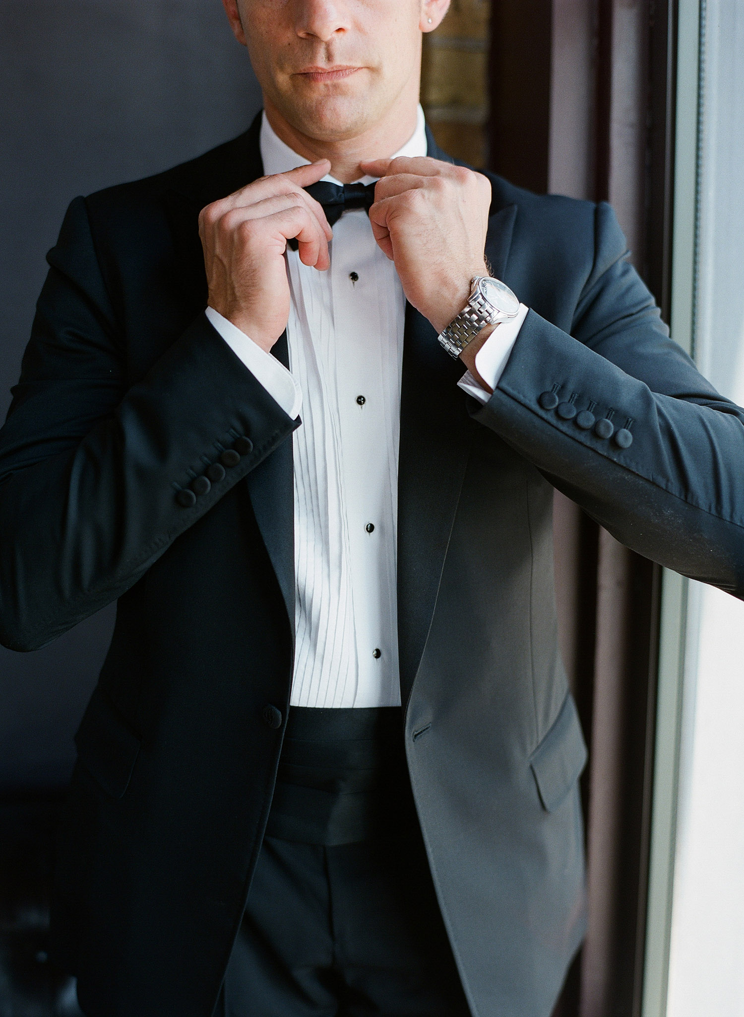 the groom adjusts his bowtie and awaits the ceremony at this beautiful italian villa wedding at the Villa Terrace where International destination wedding photographer, LExia Frank photographs the wedding on film