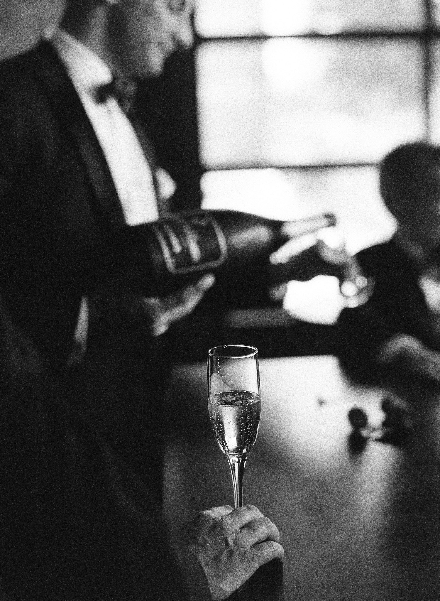 destination wedding photographer Lexia Frank photographs this Italian wedding entirely on film, at an italian villa estate called the Villa Terrace where the groom pours drinks for the groomsmen of champagne