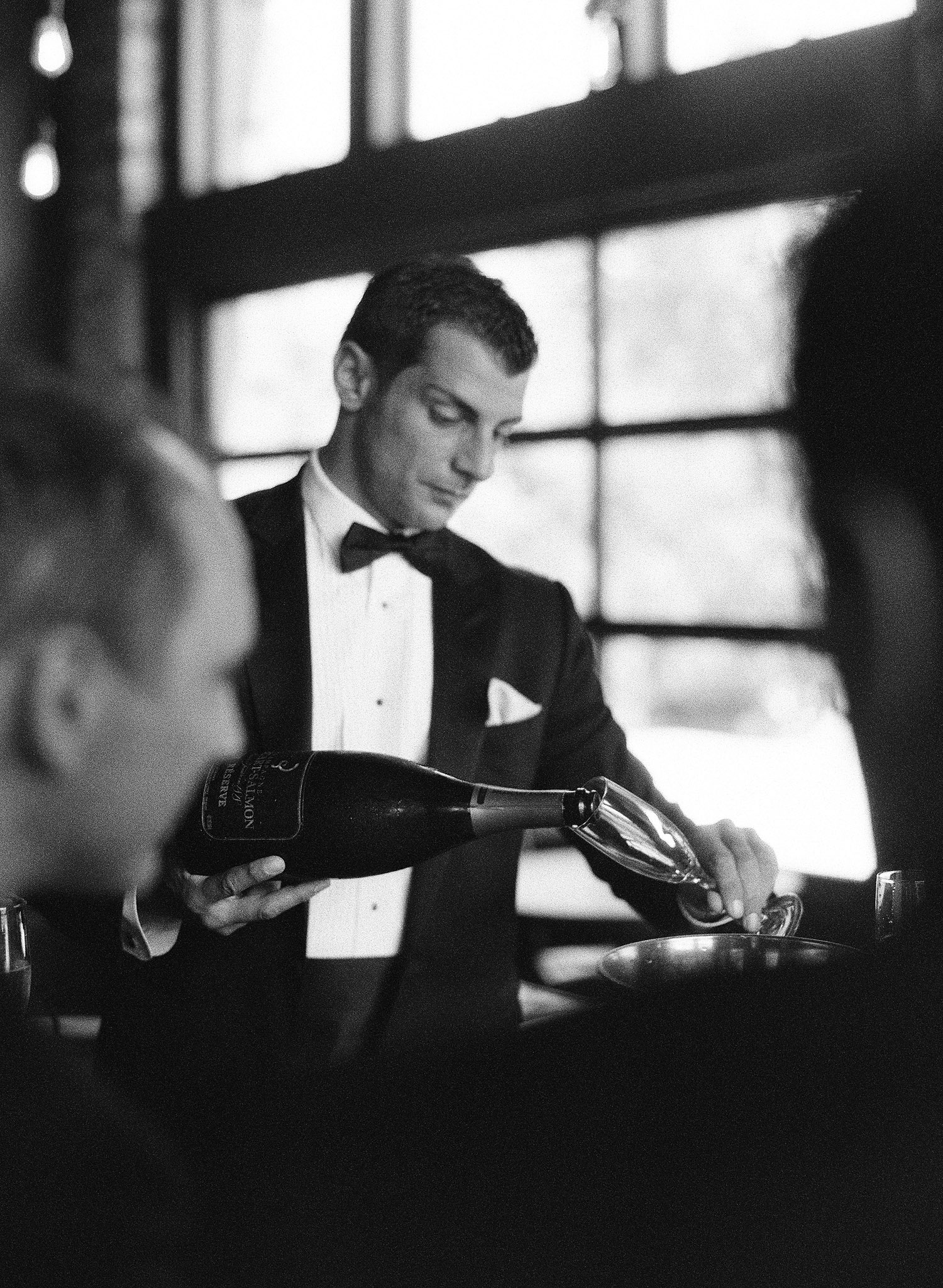 groom pours a glass of champagne for the groomsmen before his ceremony at the Italian villa named Villa Terrace where Destination wedding photographer Lexia Frank photographs this Italian destination Wedding entirely on film