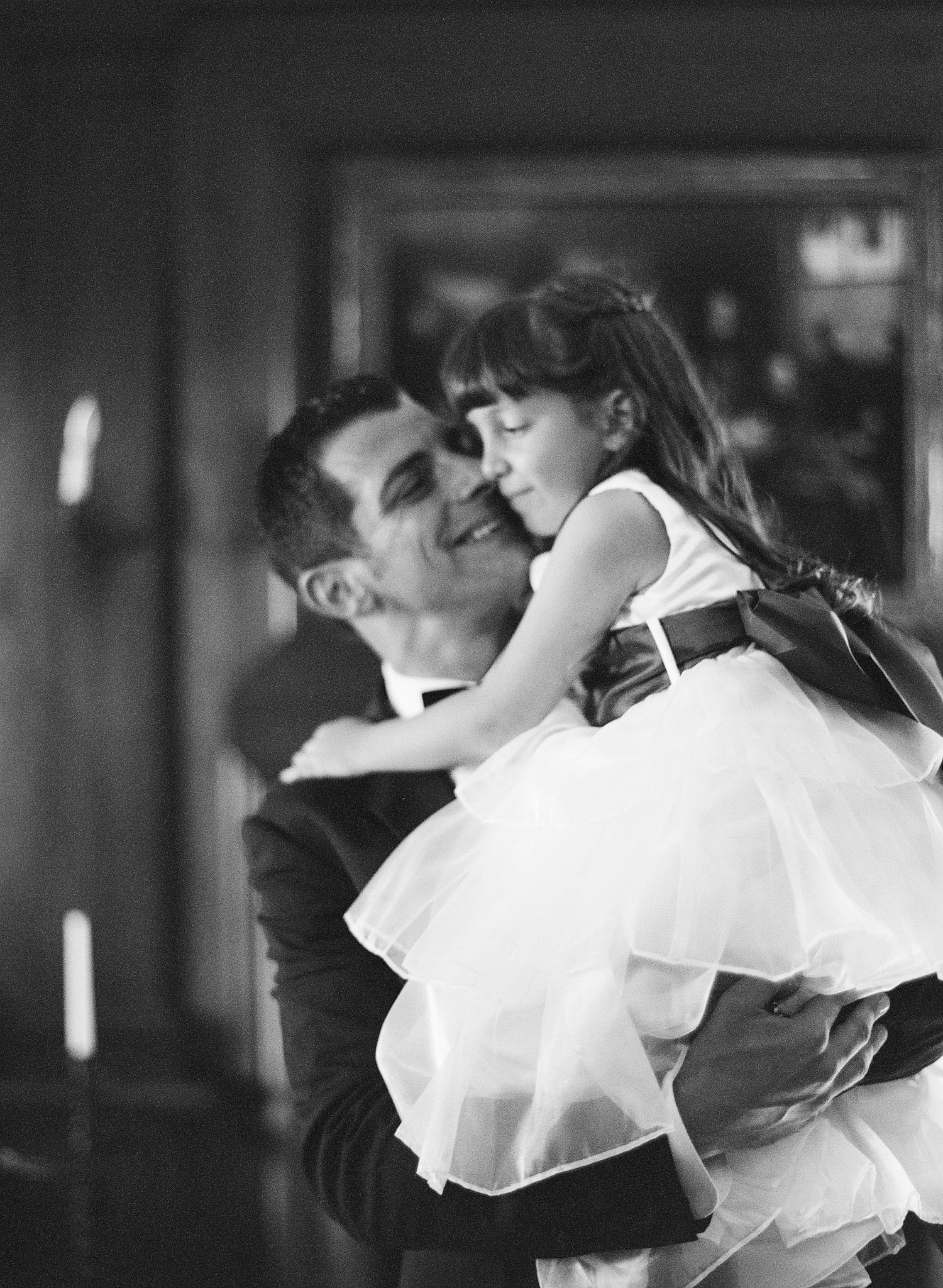 the groom hugs a flower girl at this Italian Destination Wedding at the Villa Terrace by International Destination Wedding Photographer Lexia Frank, a film photographer for weddings