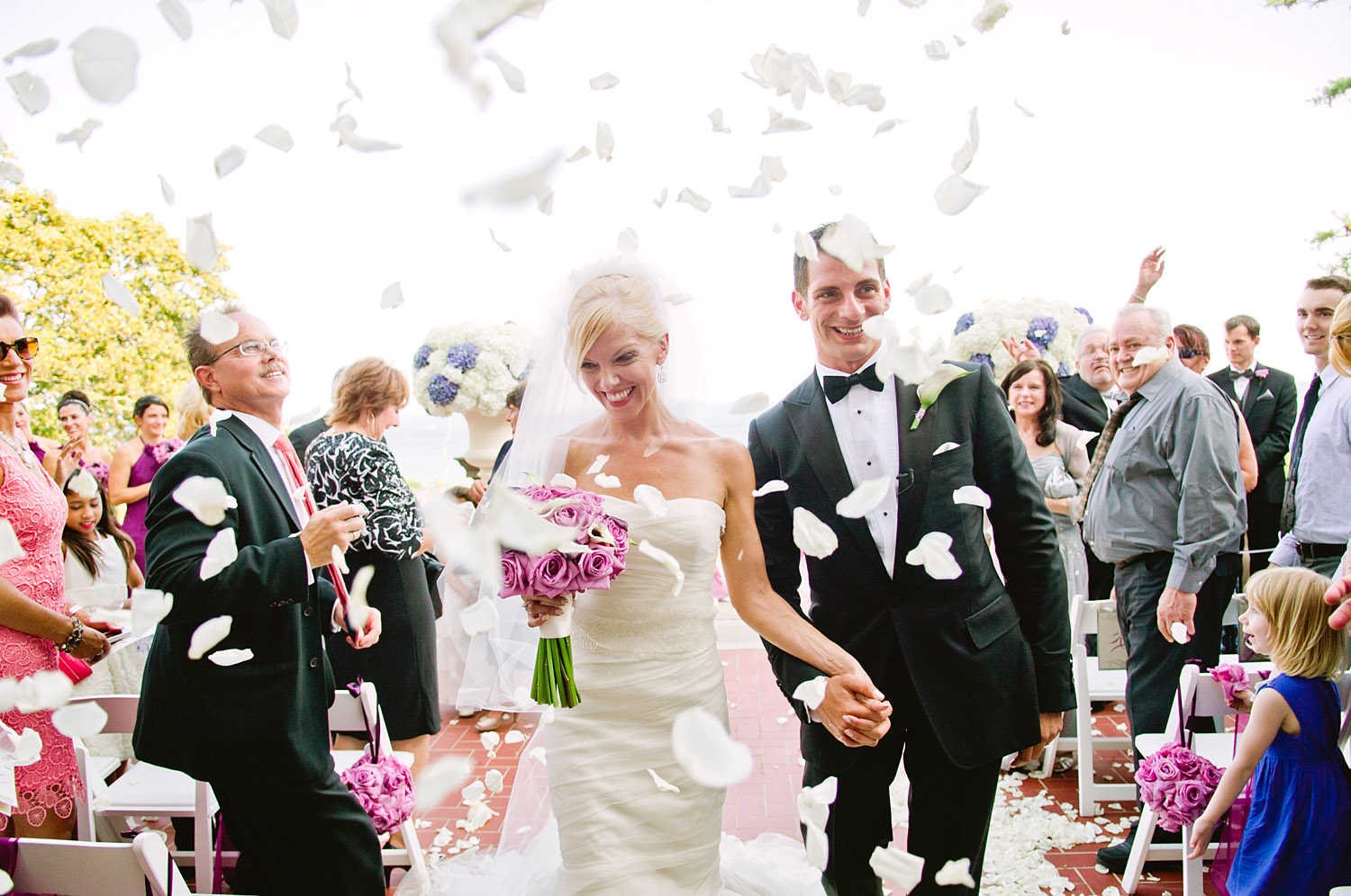 the bride and groom exit the ceremony with guests throwing rose petals at their Italian Destination Wedding at the Villa Terrace - a favorite wedding venue of Destination WEdding Photographer, Lexia Frank, who is a film photographer for luxury weddings