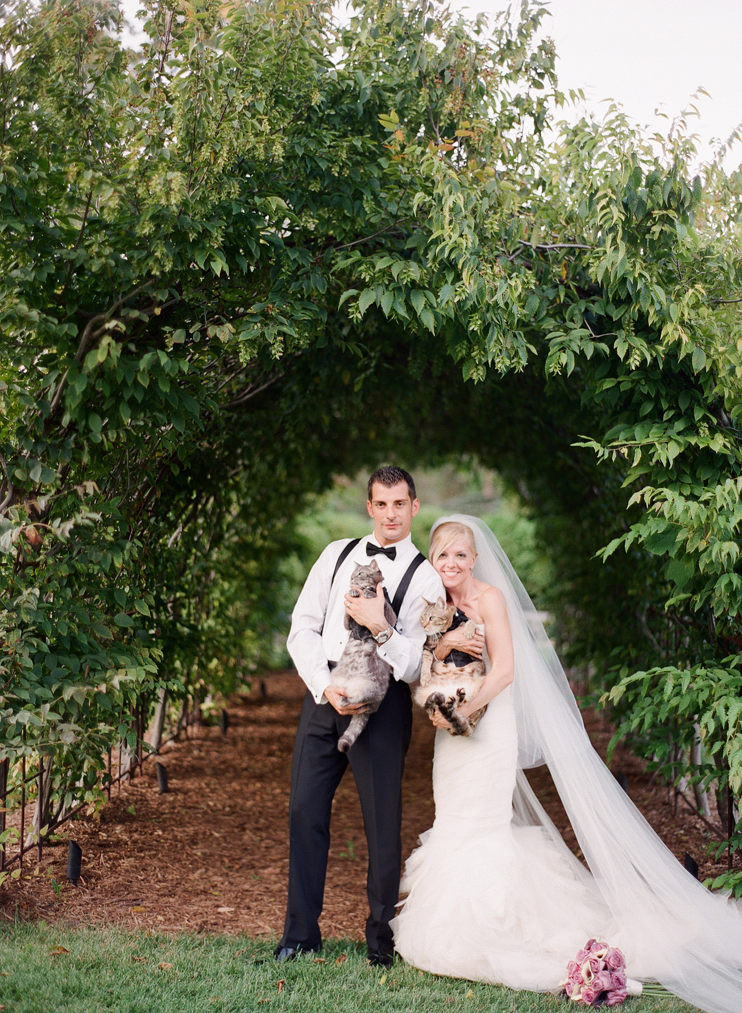 the bride and groom hold their cats dressed in tuxedos for their wedding. great idea for cats in a wedding. Destination wedding photographer Lexia Frank photographs this Italian wedding at the Villa Terrace wedding on film
