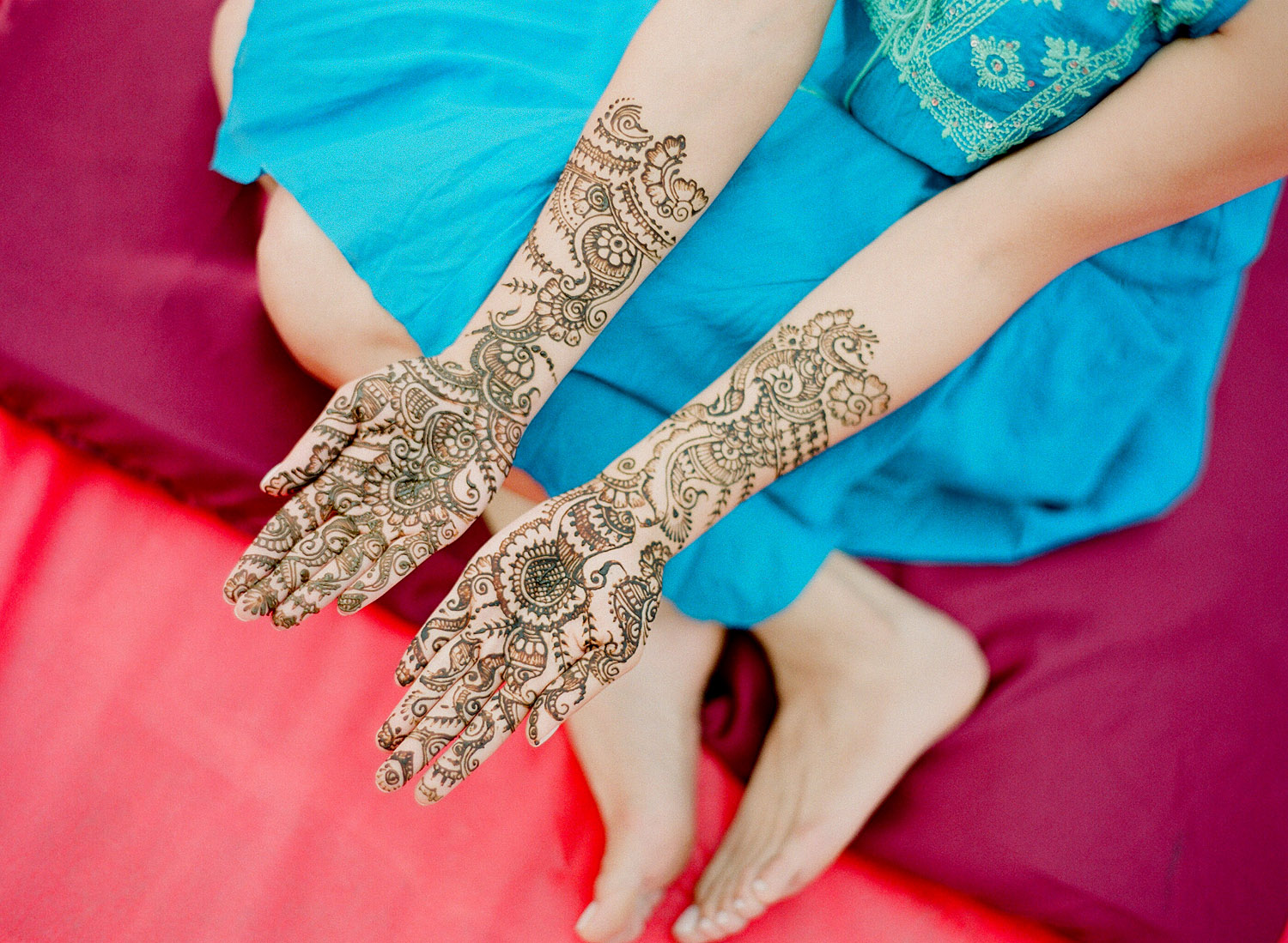 a colorful film photograph of an indian wedding mehndi ceremony in palm coast florida at the hammock beach resort with a beautiful minimalist mehndi design on an indian bride. Destination wedding photographer, Lexia Frank, is a top Indian wedding photographer photographing luxury indian weddings in florida and worldwide on film 
