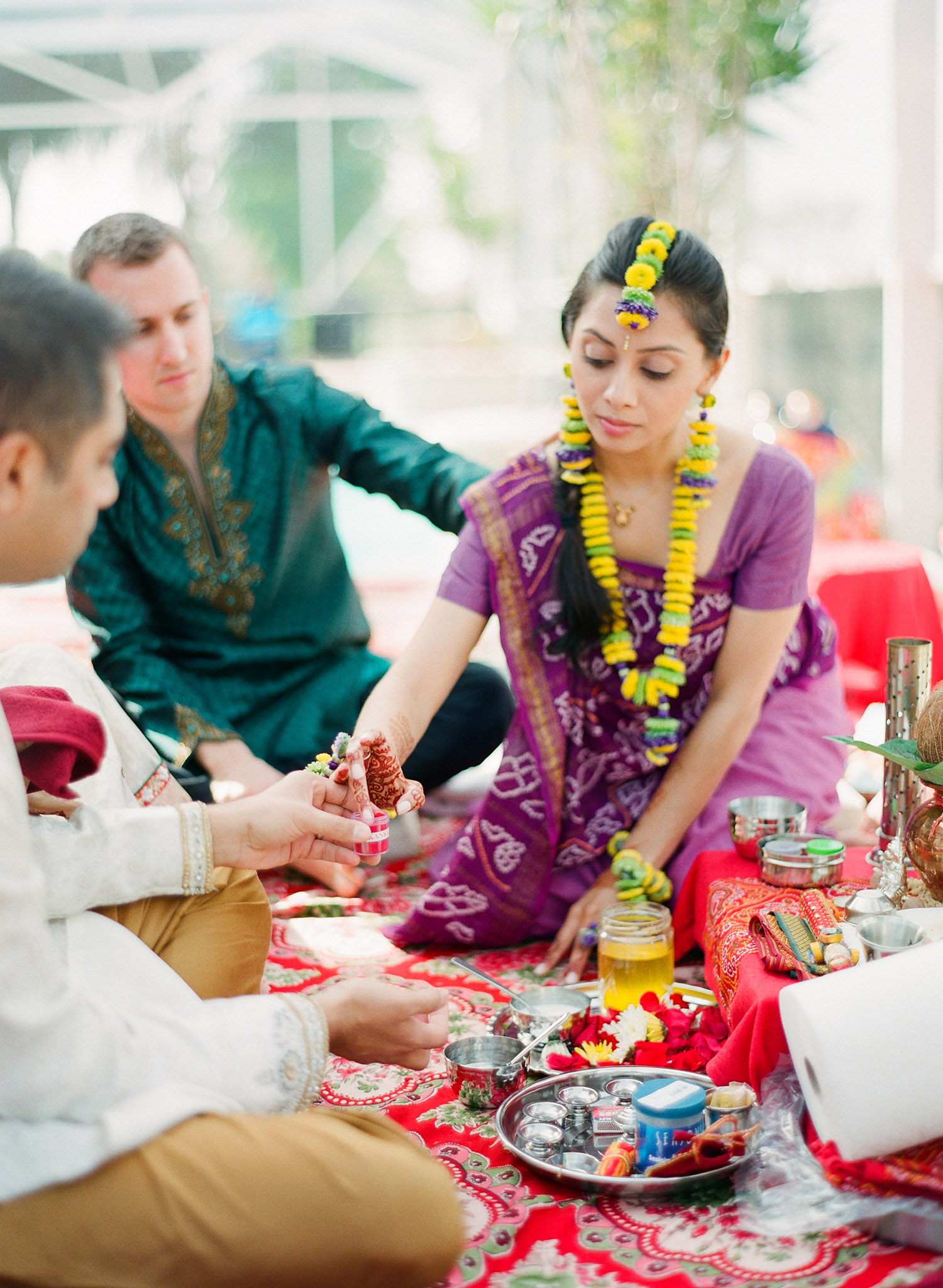 Indian bride at pithi ceremony after her mehndi ceremony in palm coast florida at hammock beach resort photographed by Destination Wedding Photographer, Lexia Frank, a top indian wedding photographer who shoots her indian weddings on film with medium format film cameras and shoots luxury indian weddings in florida and worldwide. bride wears floral jewelry and a floral tikka for her hindu indian wedding 