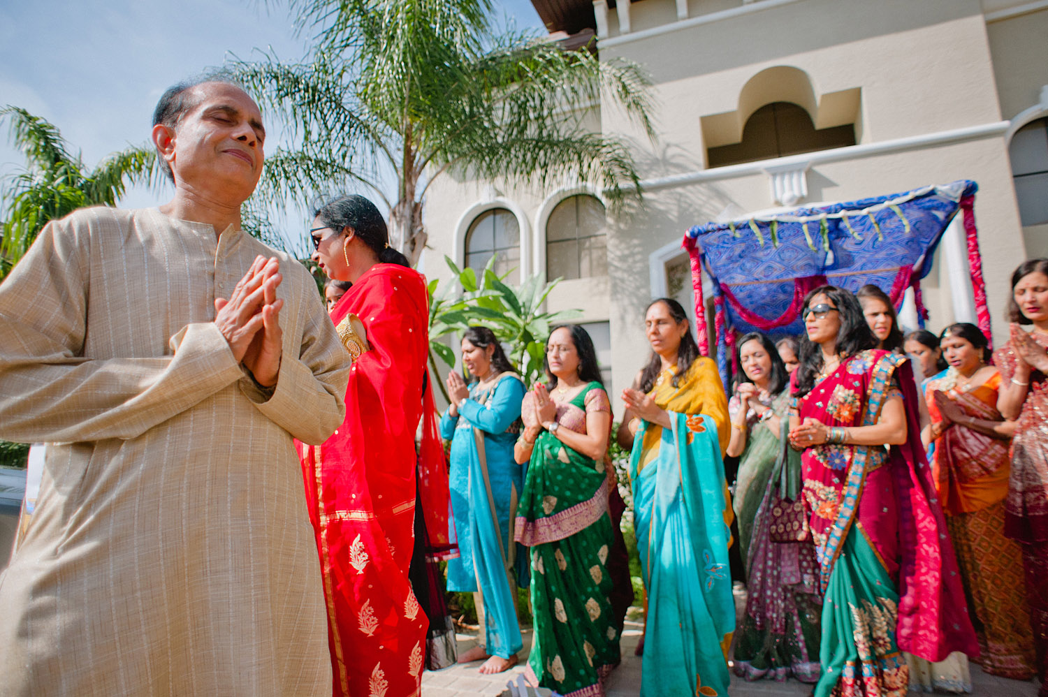 father prays during this pithi ceremony at this hindu wedding in palm coast florida while Destination Wedding Photographer Lexia Frank - a top indian wedding photographer - photographs the day on film because she is a film photographer for indian weddings who still shoots medium format film for weddings 
