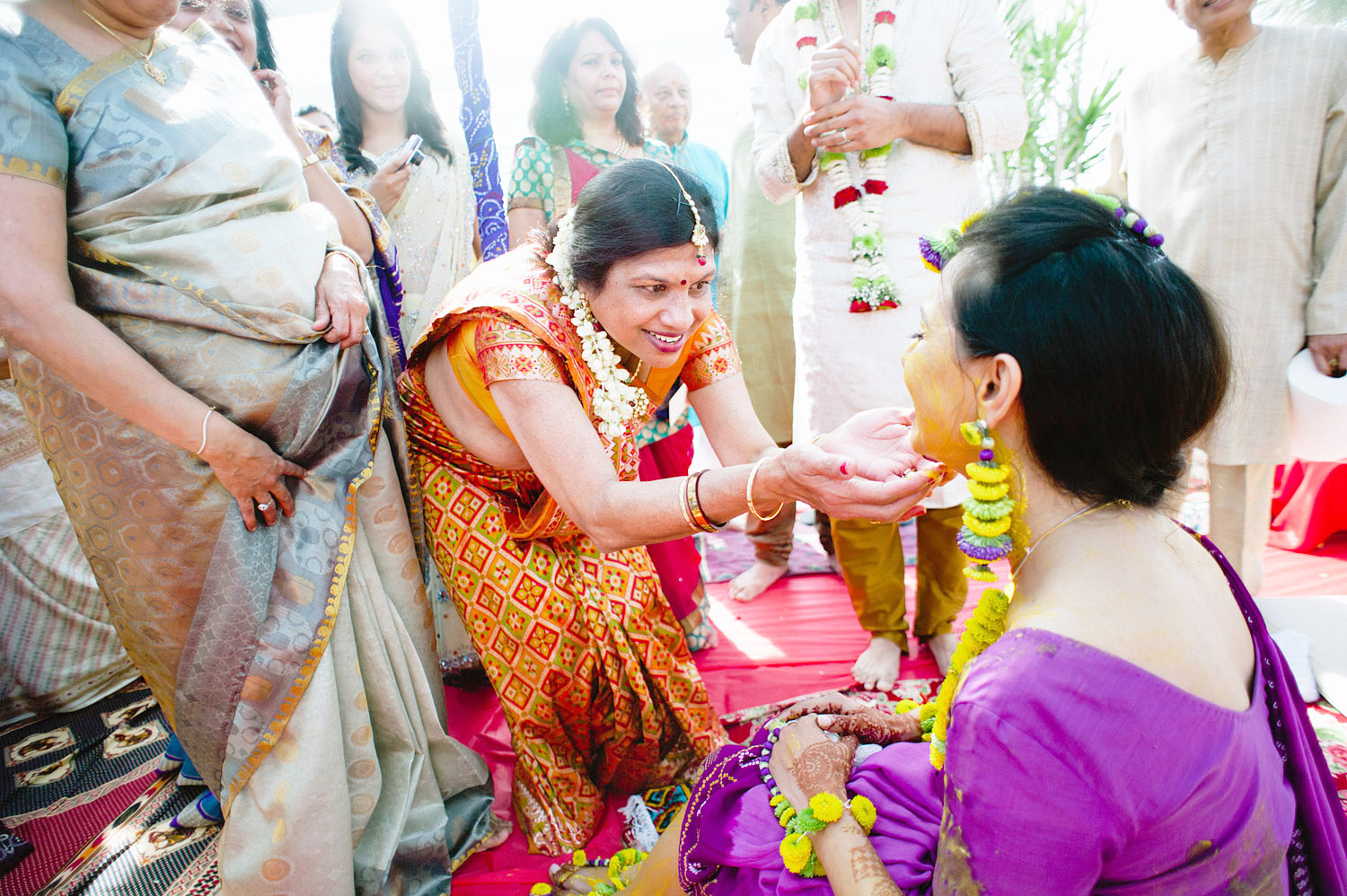 an auntie touches indian bride's face at her pithi ceremony during this hindu wedding in florida while destination wedding photographer Lexia Frank - a top indian wedding photographer , photographs this luxury indian wedding on film because she is a film photographer who shoots indian weddings for brides who love maharani weddings, south asian bride magazine photographers, and manish malhotra 