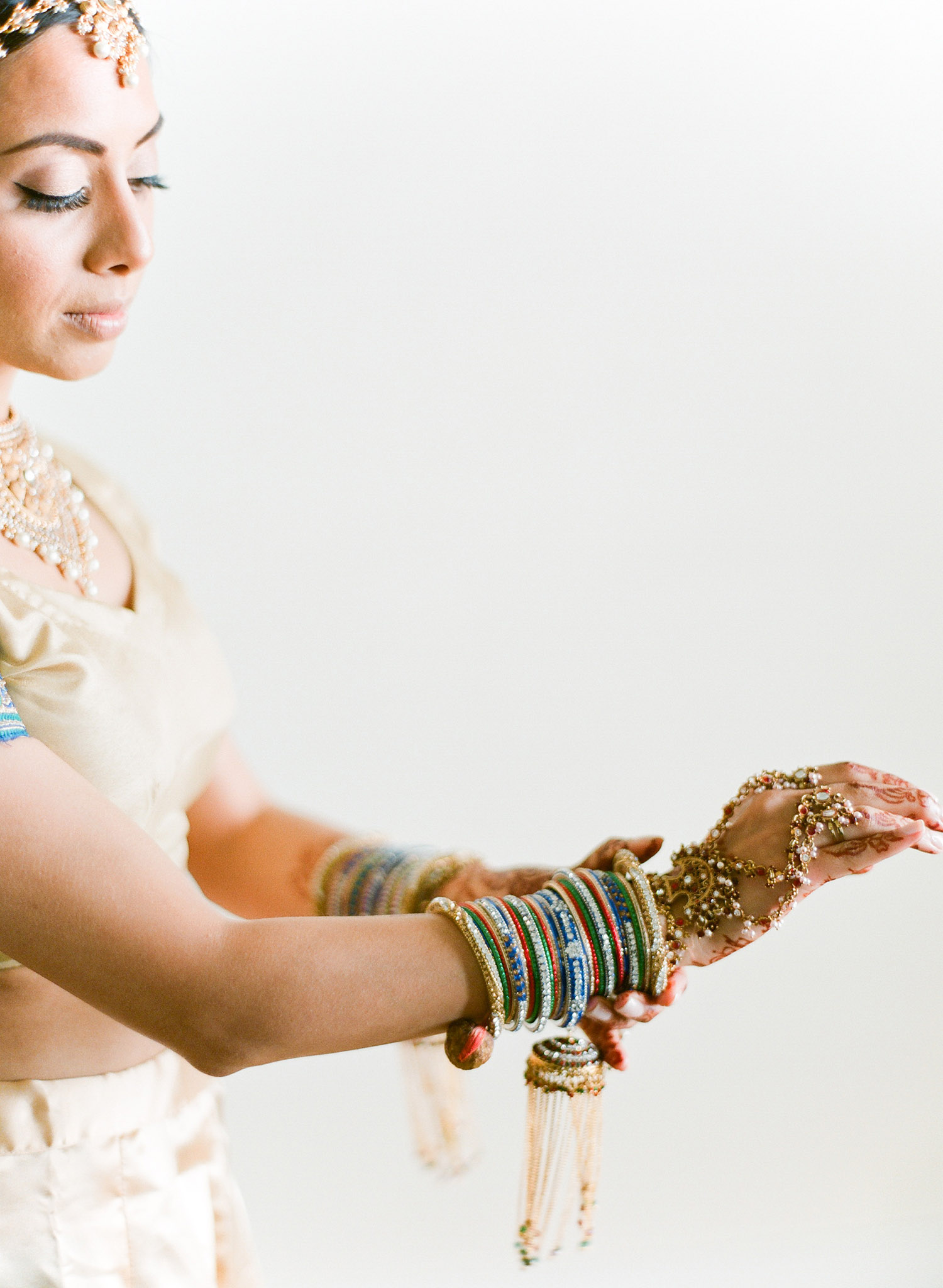 this hindu bride adjusts her bangles before her indian wedding ceremony at vizcaya miami where Destination WEdding Photographer Lexia Frank - rated top indian wedding photographer for luxury indian weddings- shoots film for this indian wedding because she prefers the soft skin tones and vibrant colors for indian weddings in india florida, and worldwide. manish malhotra and suneet varna 