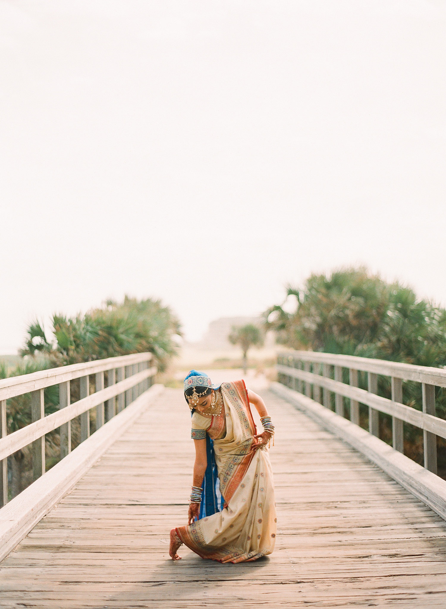 a hindu bride adjusts her saree before her indian wedding in florida photographed by Destination Wedding Photographer, Lexia Frank- a top indian wedding photographer. Lexia Photographs her luxury indian weddings on film preferring the tonal ranges and vibrant colors of film for luxury indian weddings in india, Florida, and worldwide.