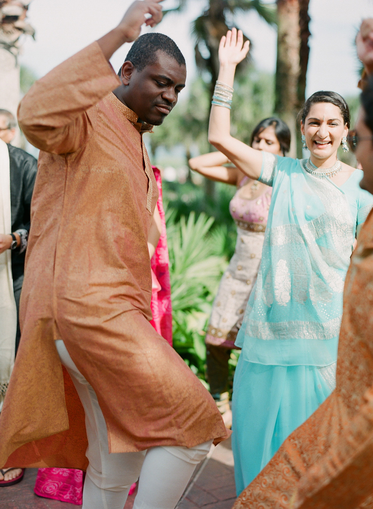 people dance at the groom's parade at this Indian Wedding in Florida photographed by Destination Wedding Photographer, LExia Frank - a top indian wedding photographer - who shoots film for luxury indian weddings preferring the soft skin tones and vibrant colors for indian weddings in india and worldwide