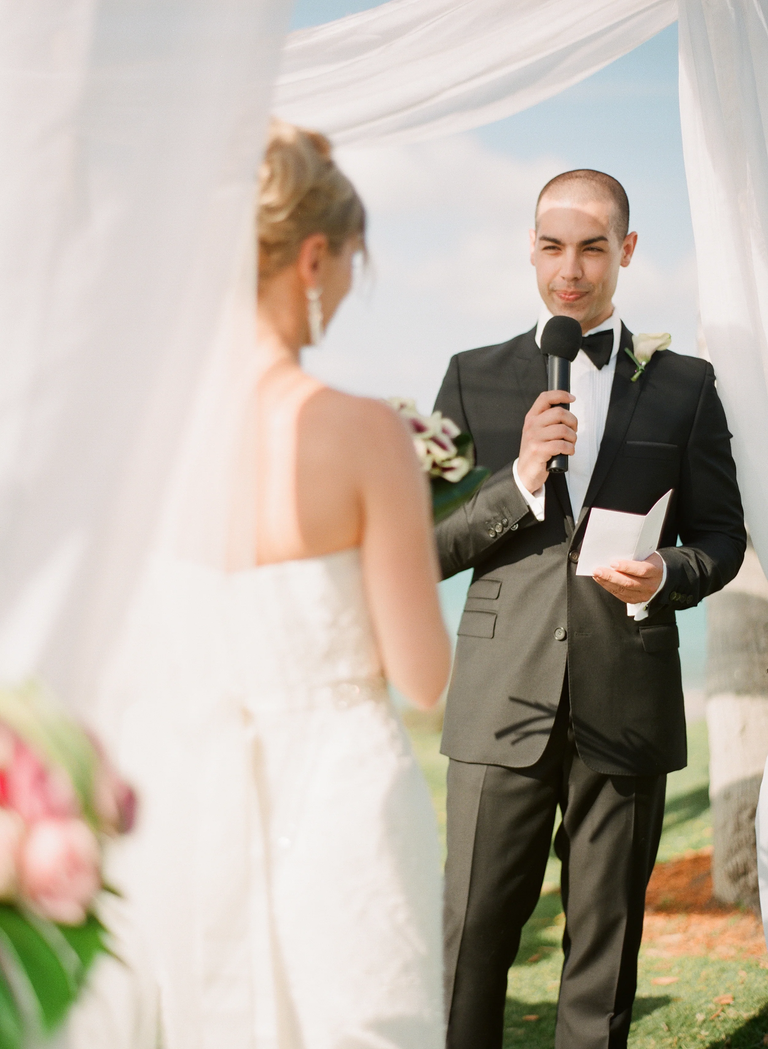 a groom recites his vows under the white canopy during his destination wedding at Vieques Island photographed by Destination Wedding Photographer, Lexia Frank, a film photographer specializing in destination weddings and luxury weddings worldwide. 