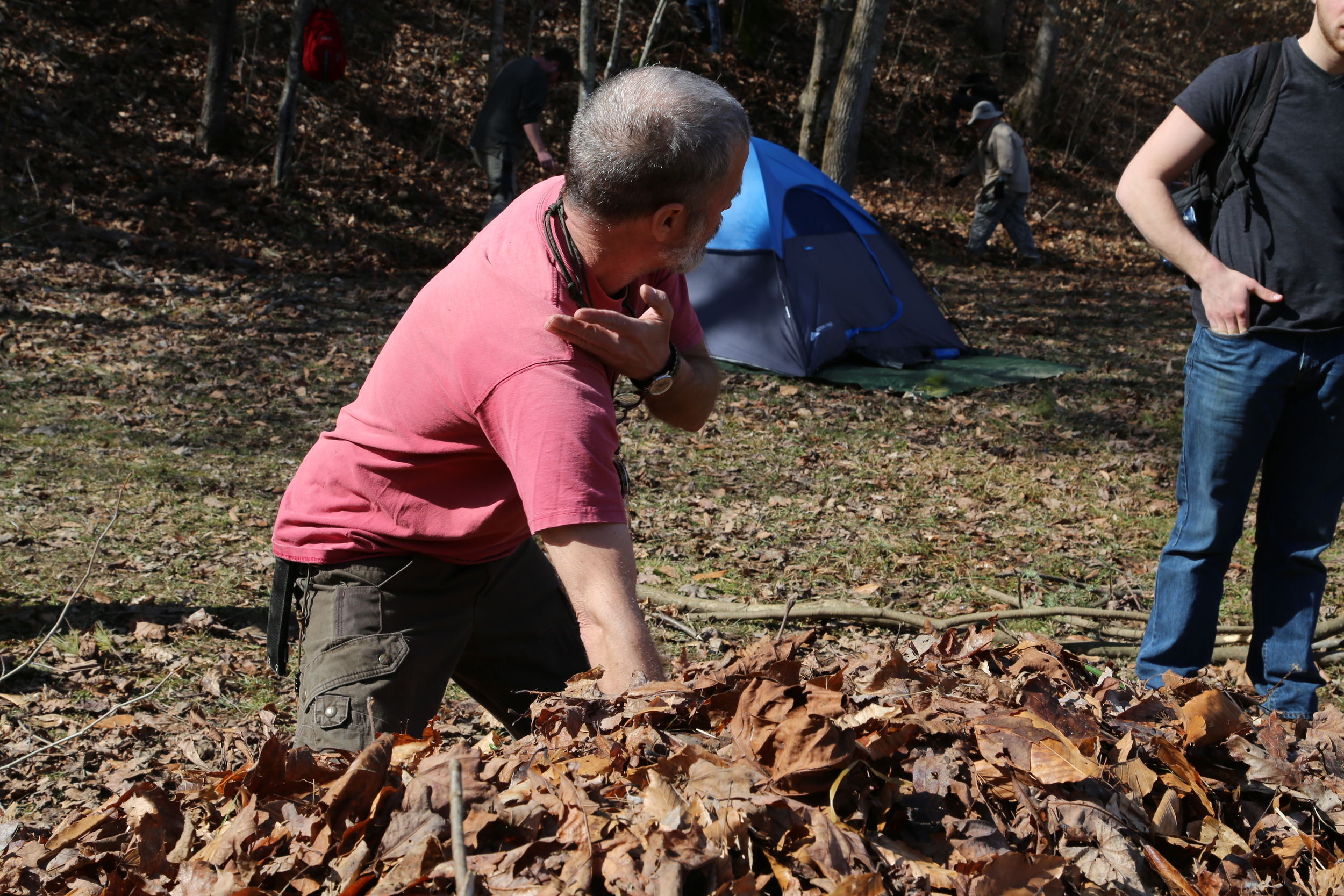 As John demonstrates in this photo, the debris hut shelter requires a significant depth of leaves in order to provide adequate insulation and rainproof qualities. Photo by Todd Nystrom