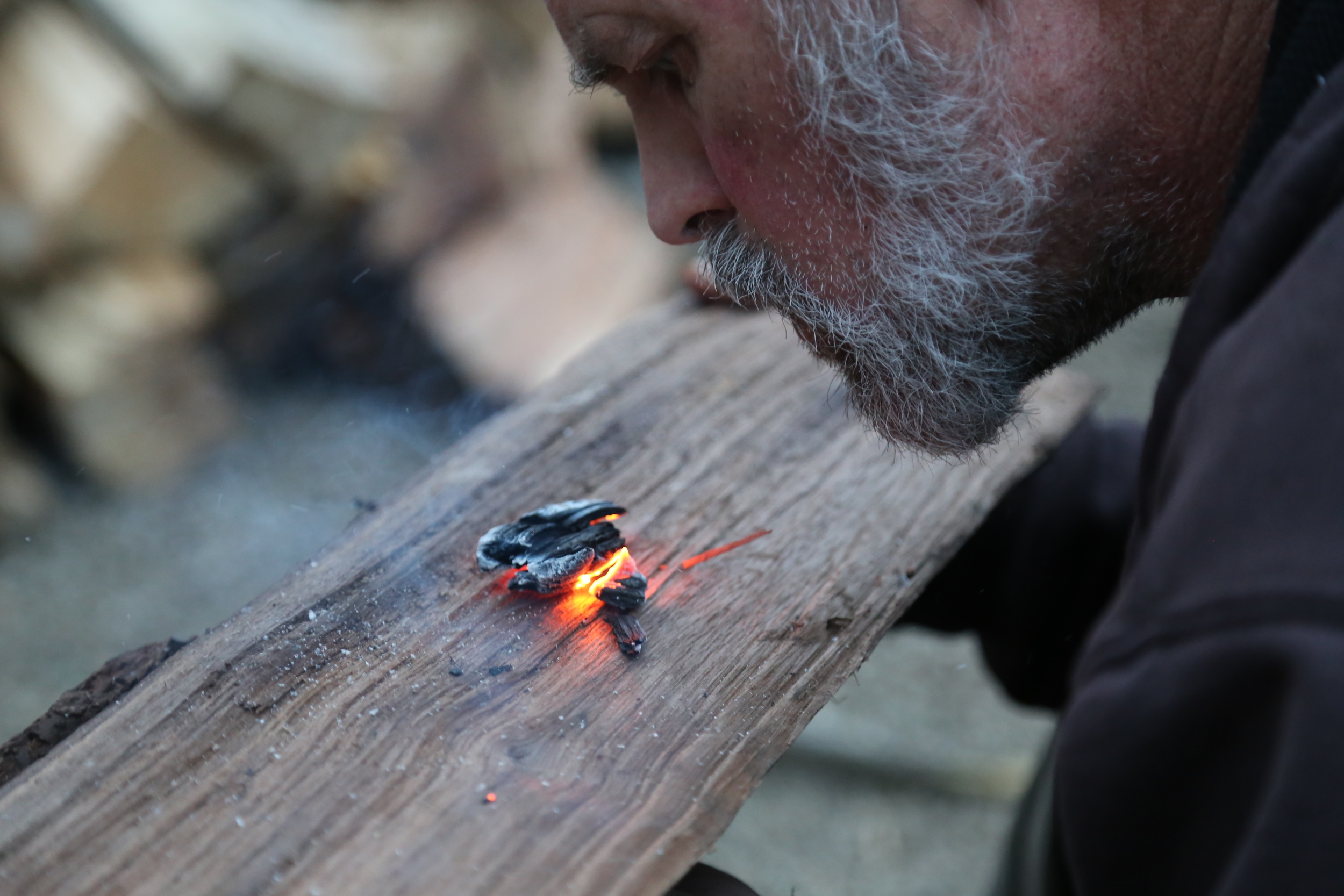 John demonstrates “coal burning,” a technique for making bowls, spoons, and other implements that make survival easier, as well as passing time around the campfire. Photo by Todd Nystrom.