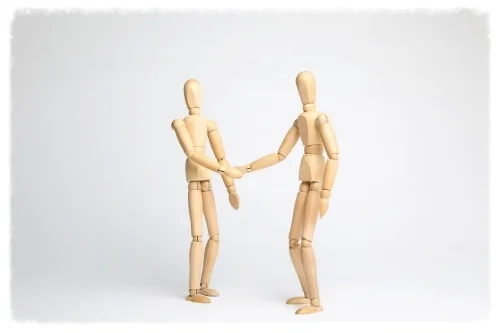 Wooden mannequins shaking hands