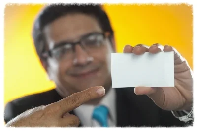 Mature businessman holding blank business card, studio shot