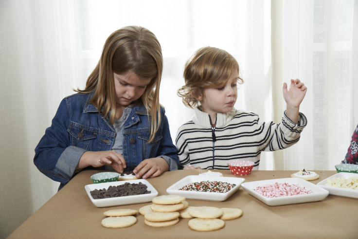 Put brown paper over your table to protect it. Place all of the decorating supplies in low plates or shallow bowls to make it easy for little hands.
