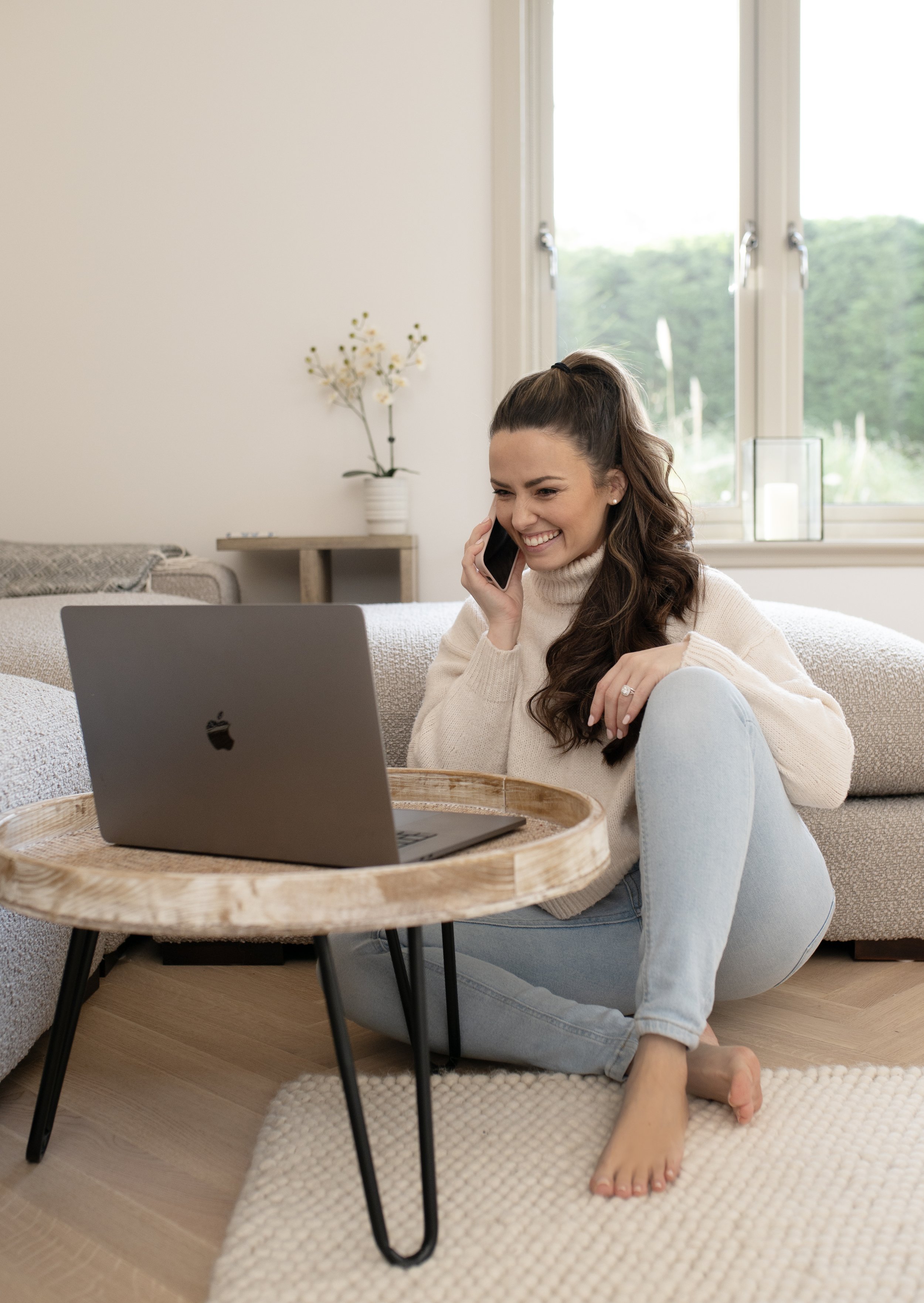 Victoria Haydn, Cheshire brand photographer, working from home on a laptop and phone call