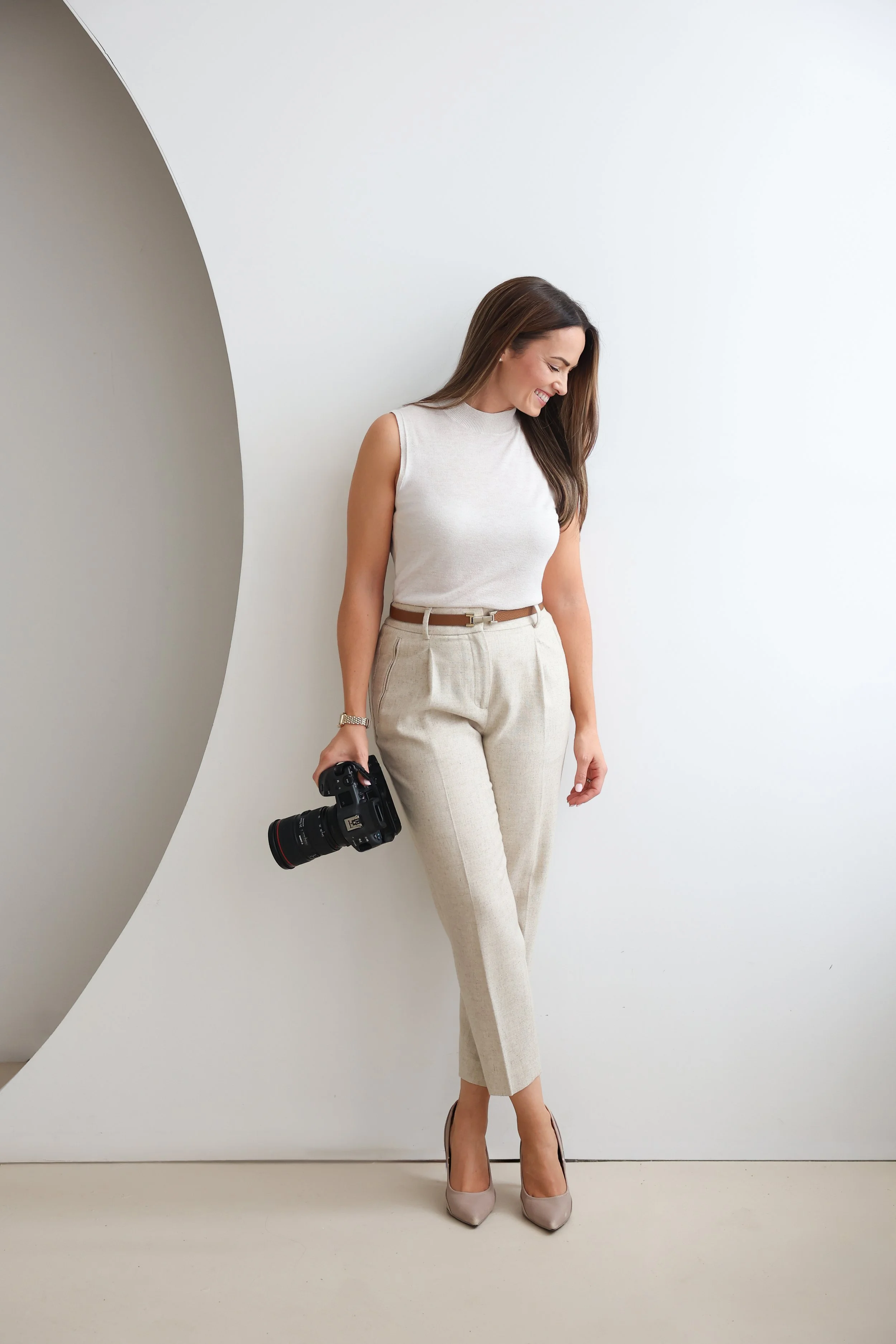 Victoria Haydn photographer stands holding camera in studio
