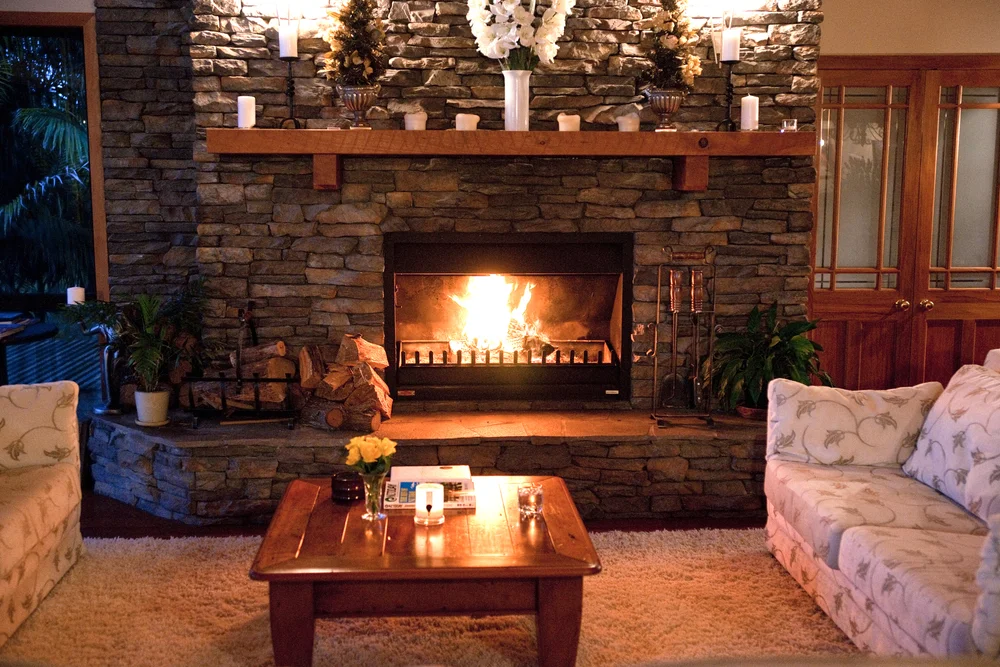 The stone fireplace alight in the Great Room, with seating around it