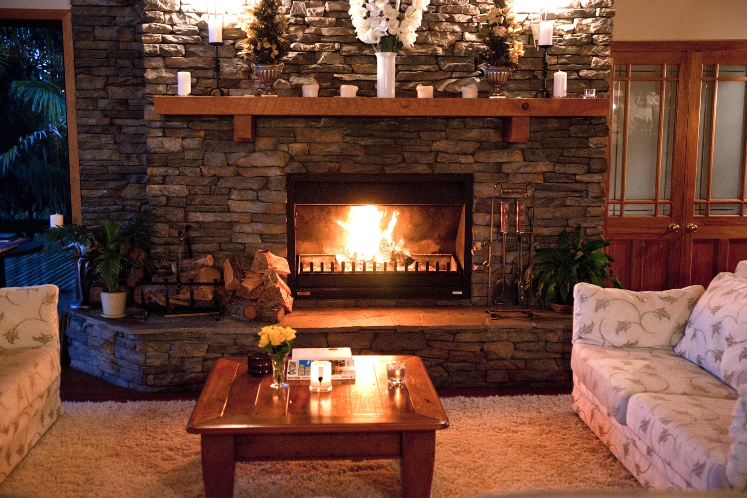 The stone fireplace alight in the Great Lounge, with seating around it