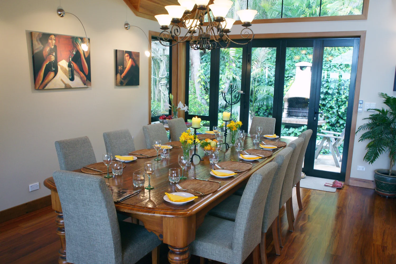 The dining table set for eight beside the garden windows