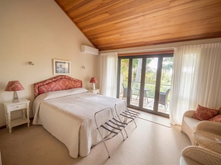 Balcony suite bedroom with cedar ceiling and doors open to the balcony