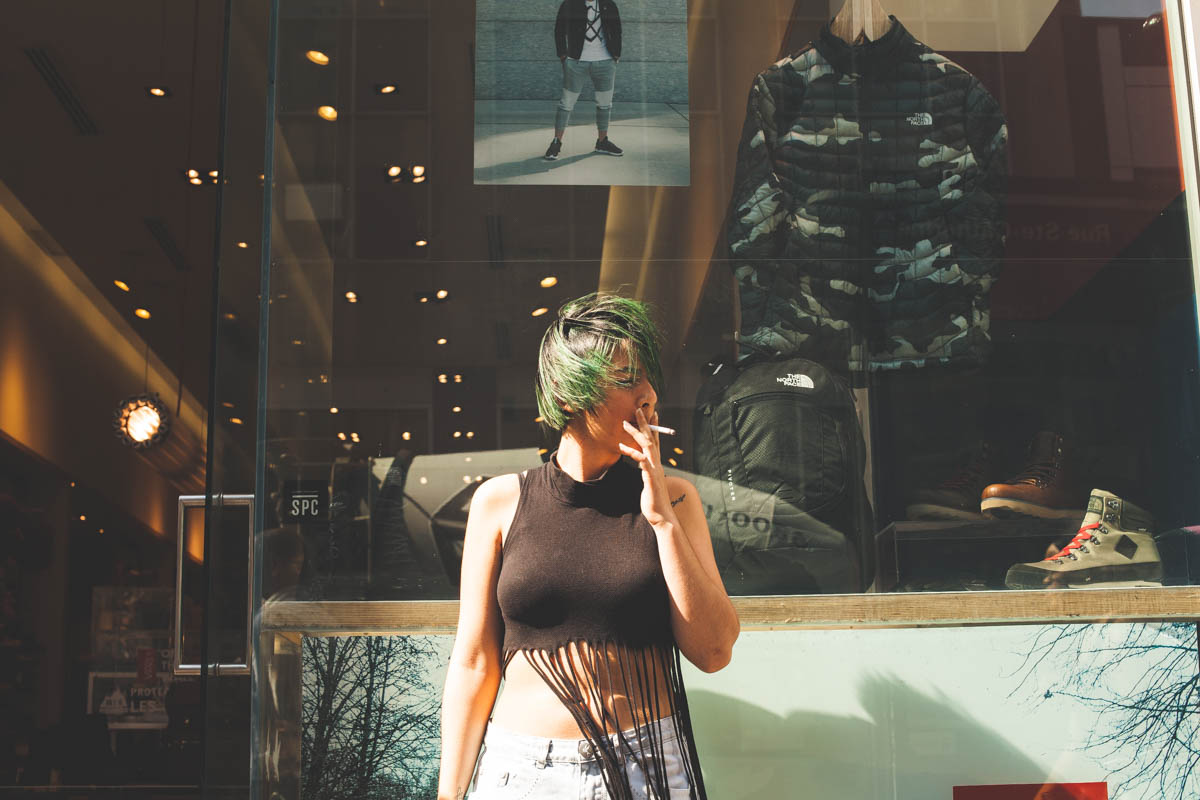 A woman named Sherry having a smoke break outside of the clothing store she worked at. 