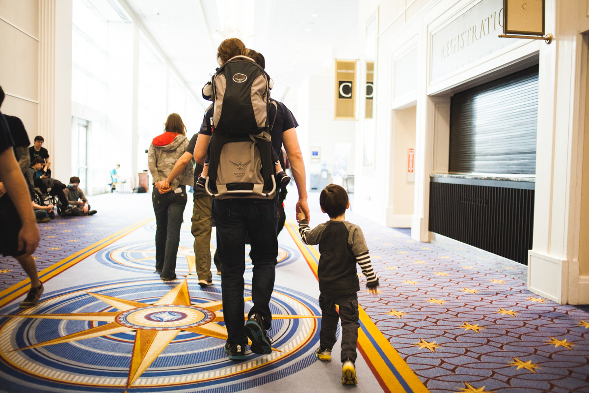 A father leads his children through the different rooms of the convention.