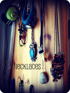 These are just layered necklaces held up by push pins in a row.