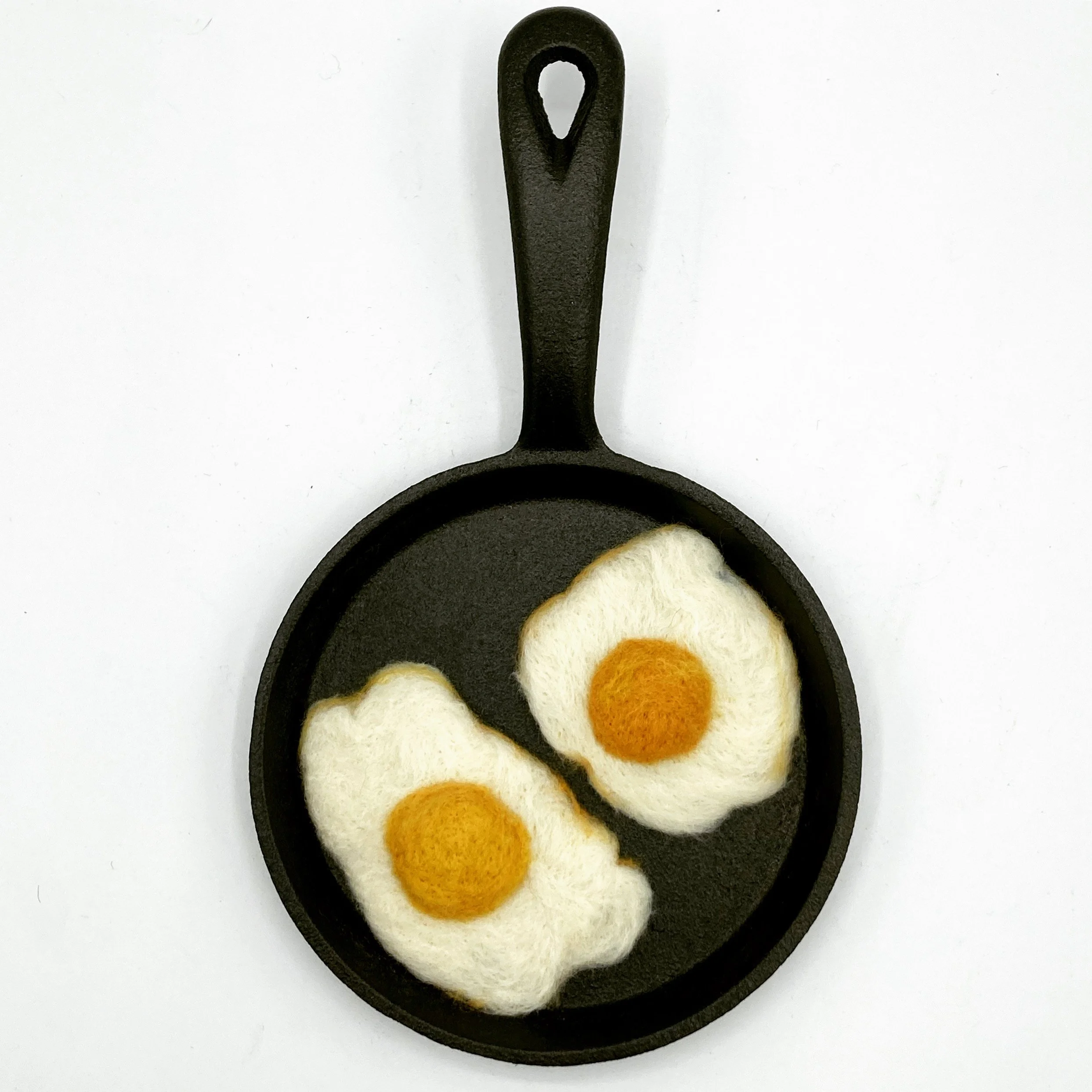 Two fried eggs in a cast iron skillet