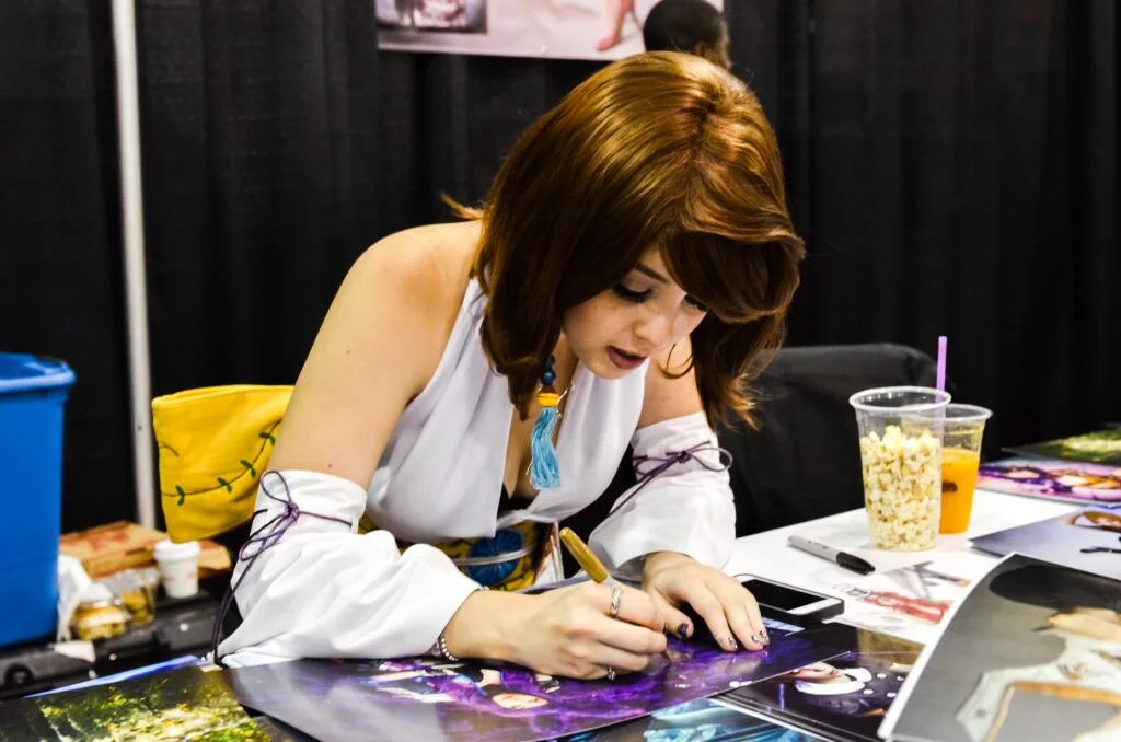 Signing photos for fans at Calgary Expo in 2014.