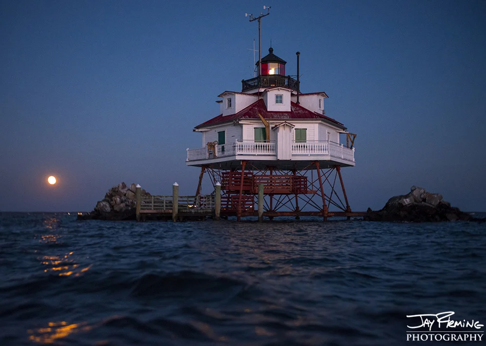 the November full moon rises behind Thomas Point Shoal Light. Annapolis, Maryland 