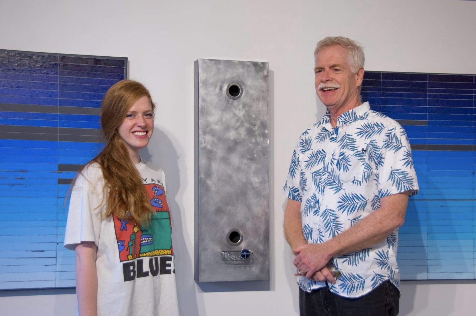Mia and Doug Cross with Mia's painting "The Color Blues I Would Miss Most if I Went Blind, Part 2" and Doug's sculpture "9 to 5"